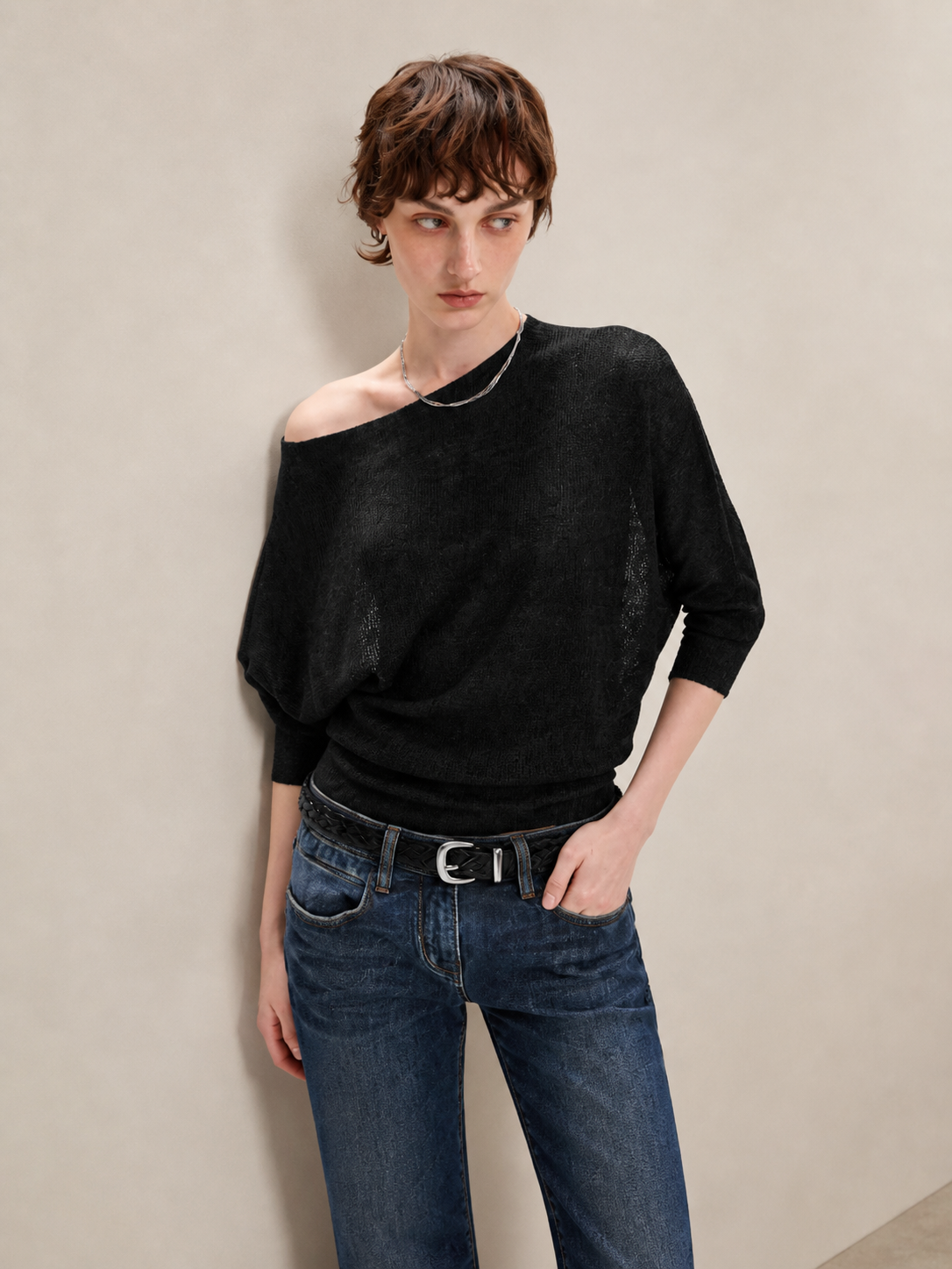 Black asymmetric off shoulder batwing knit top, close-up view