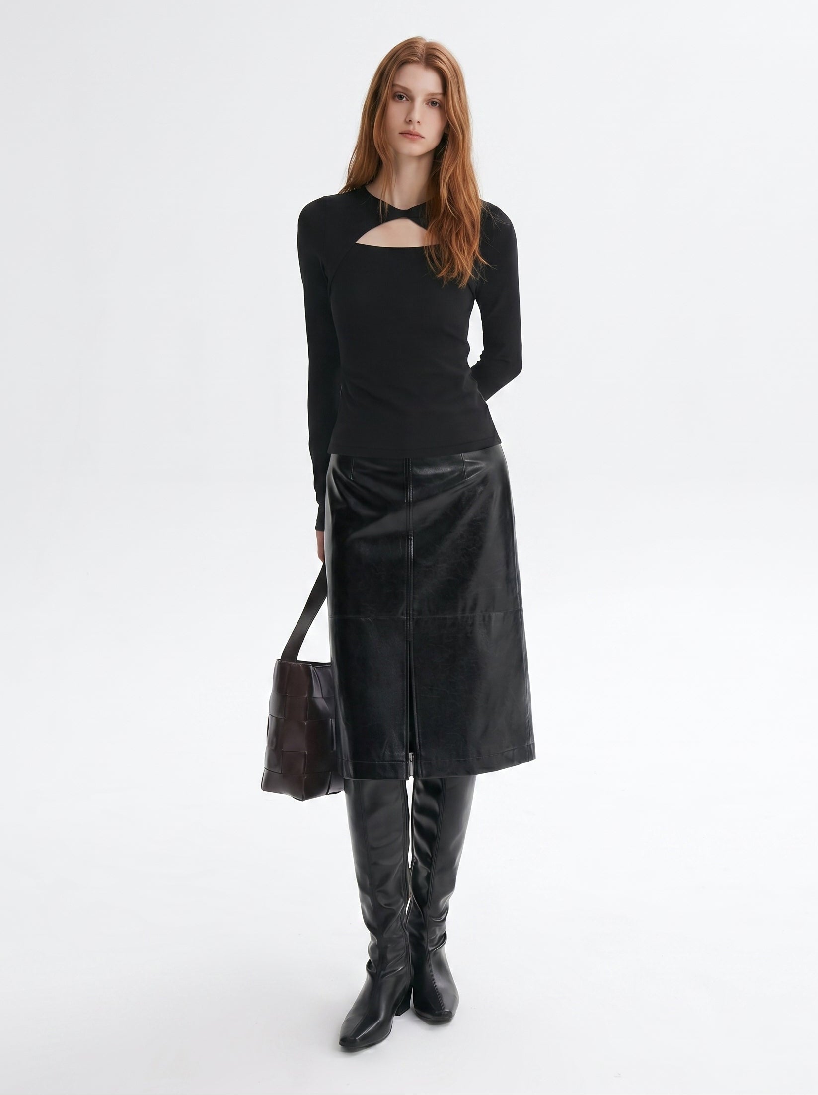 Black asymmetric cutout long sleeve top styled with a black skirt and knee high boots