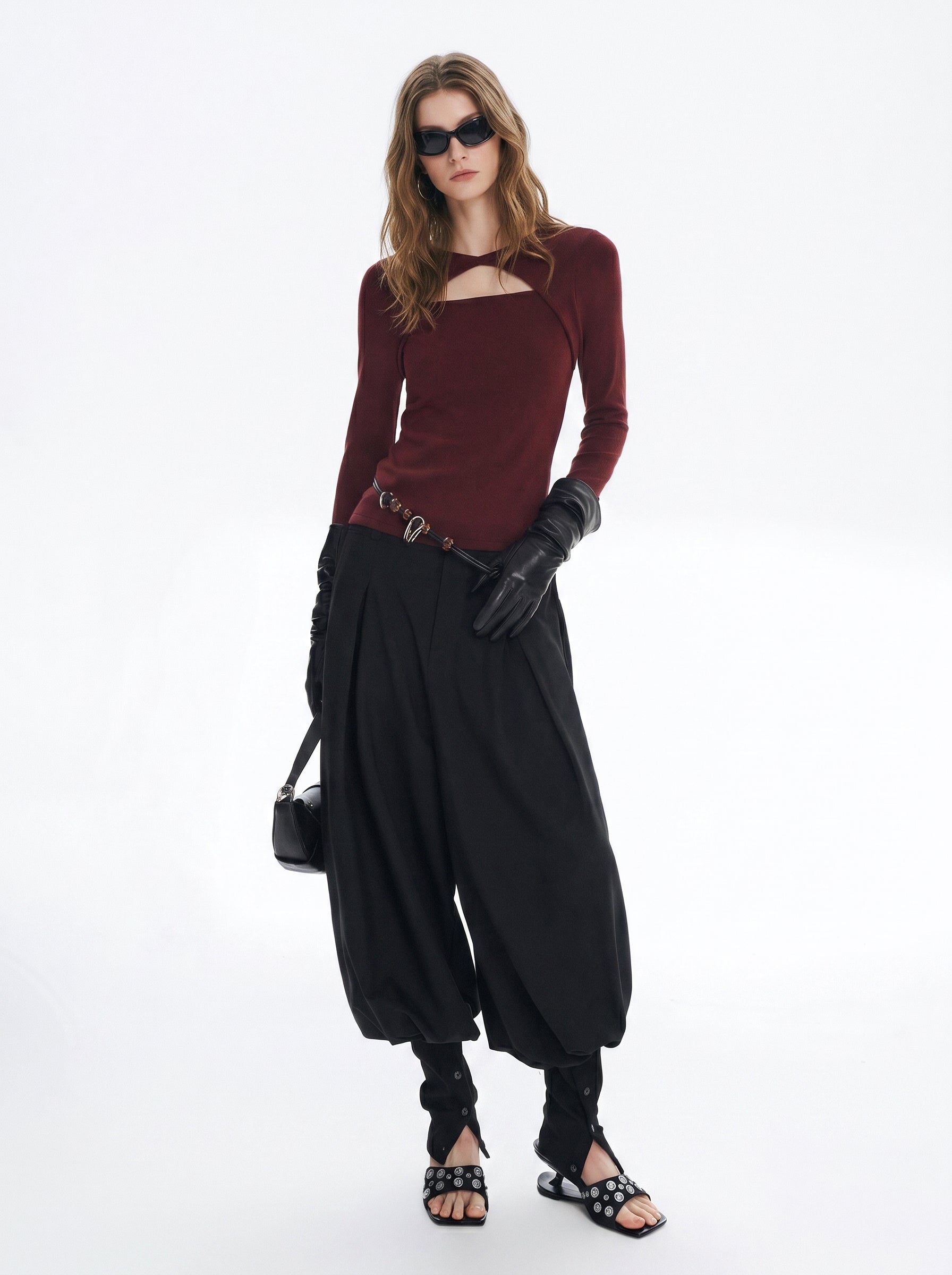 Burgundy asymmetric cutout long sleeve top styled with a black skirt and sandals