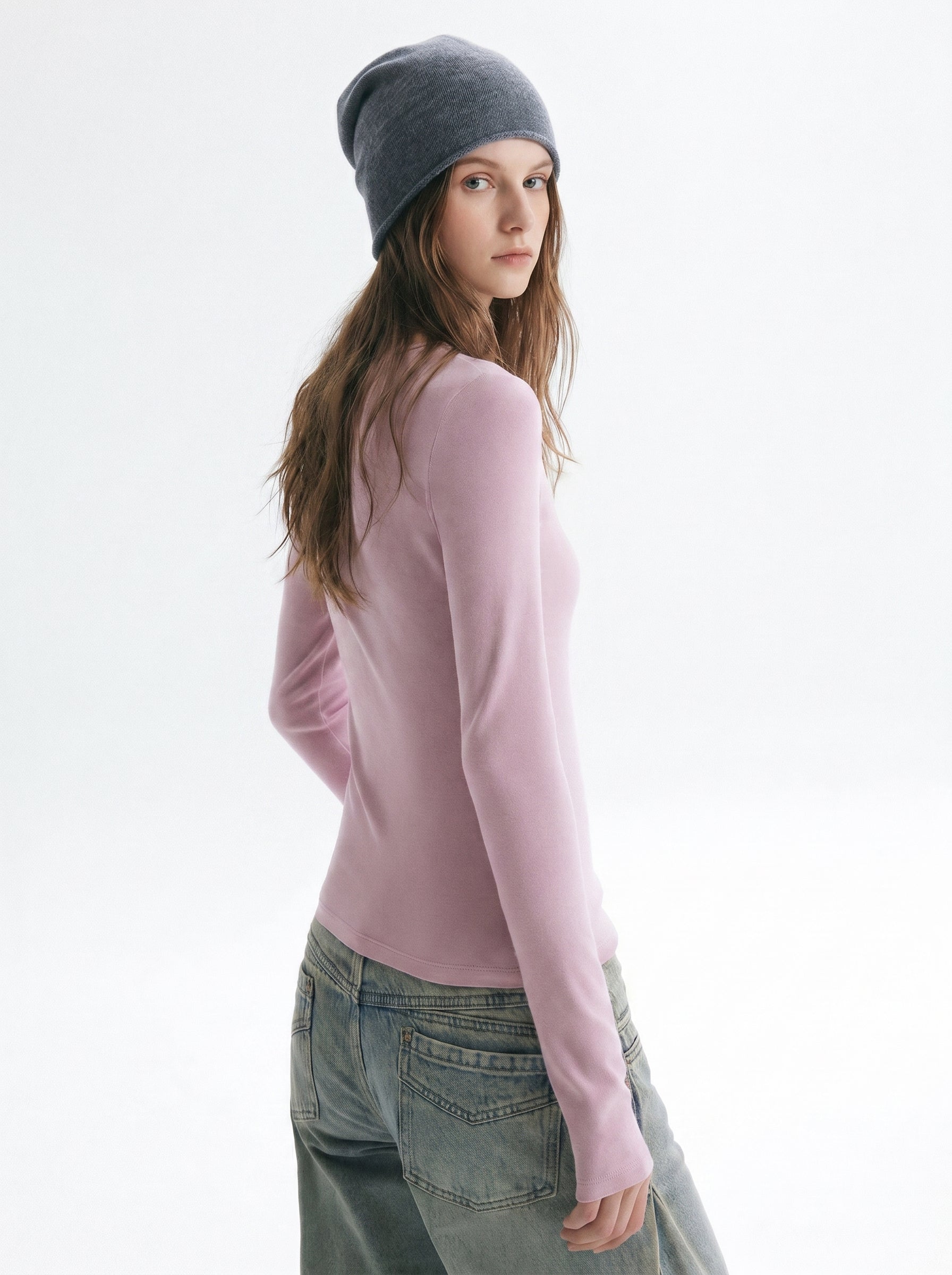 Side view of pink asymmetric cutout long sleeve top showing the slim fit and long sleeve silhouette