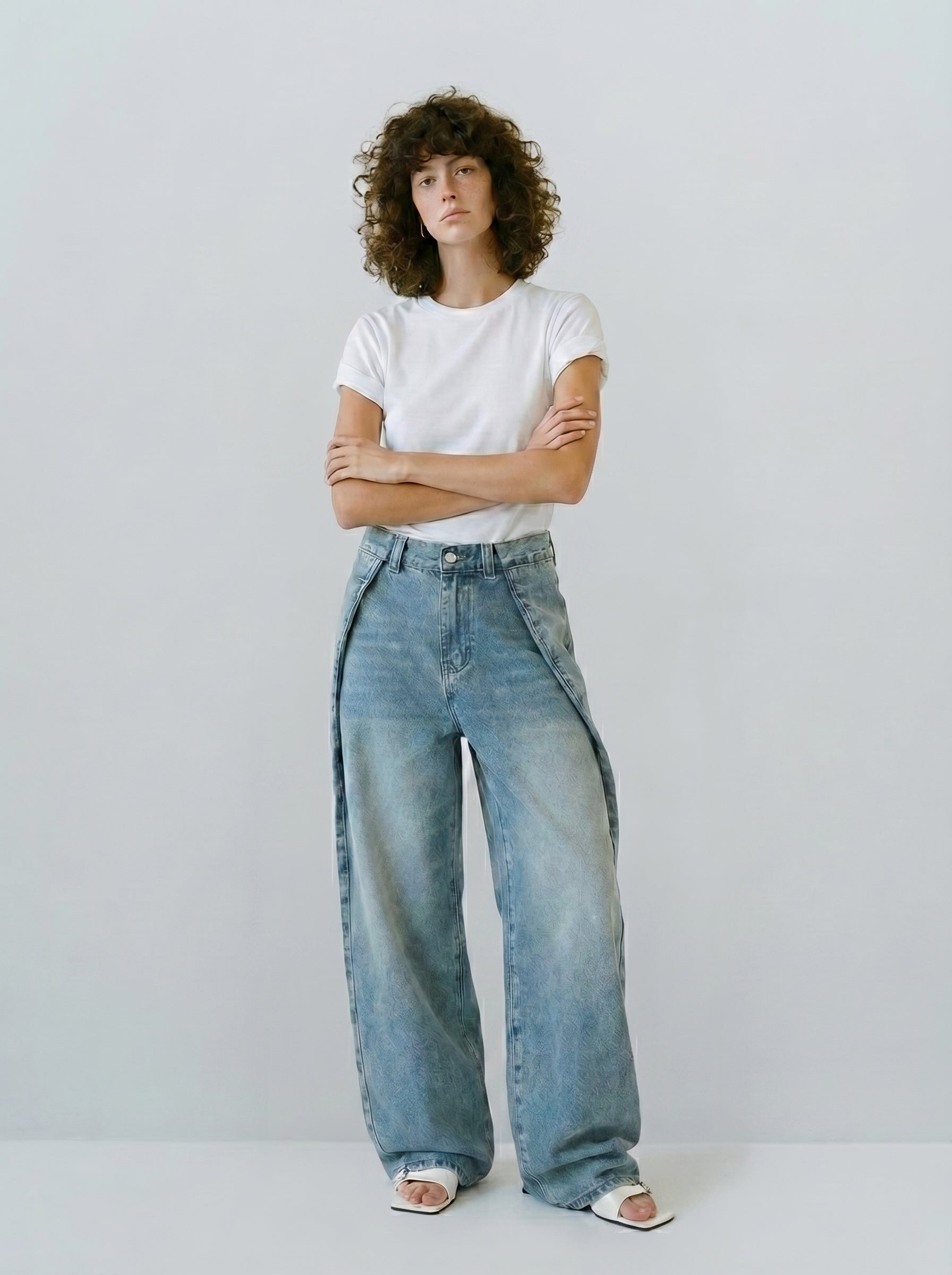Full-body front view of asymmetric cut vintage wide jeans