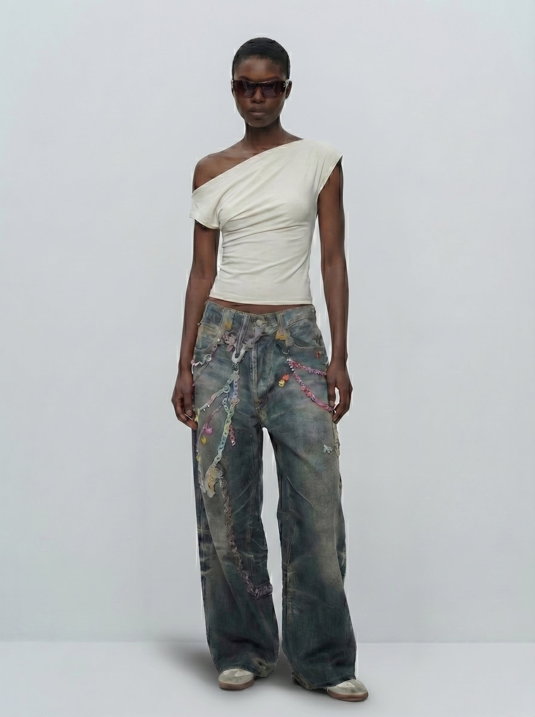 Model wearing dark-wash baggy jeans with pastel chain print