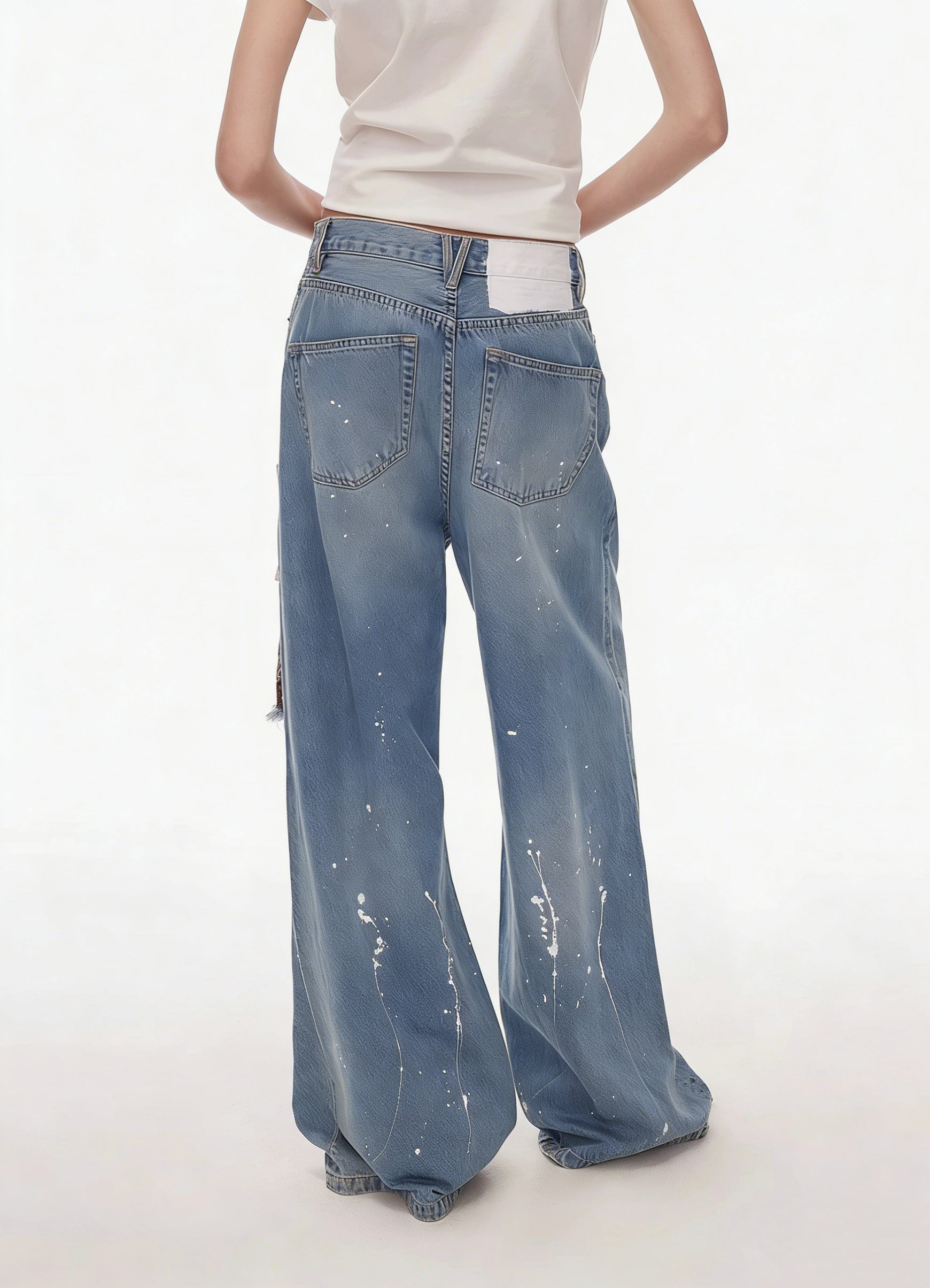 Back view of blue patchwork distressed wide-leg jeans