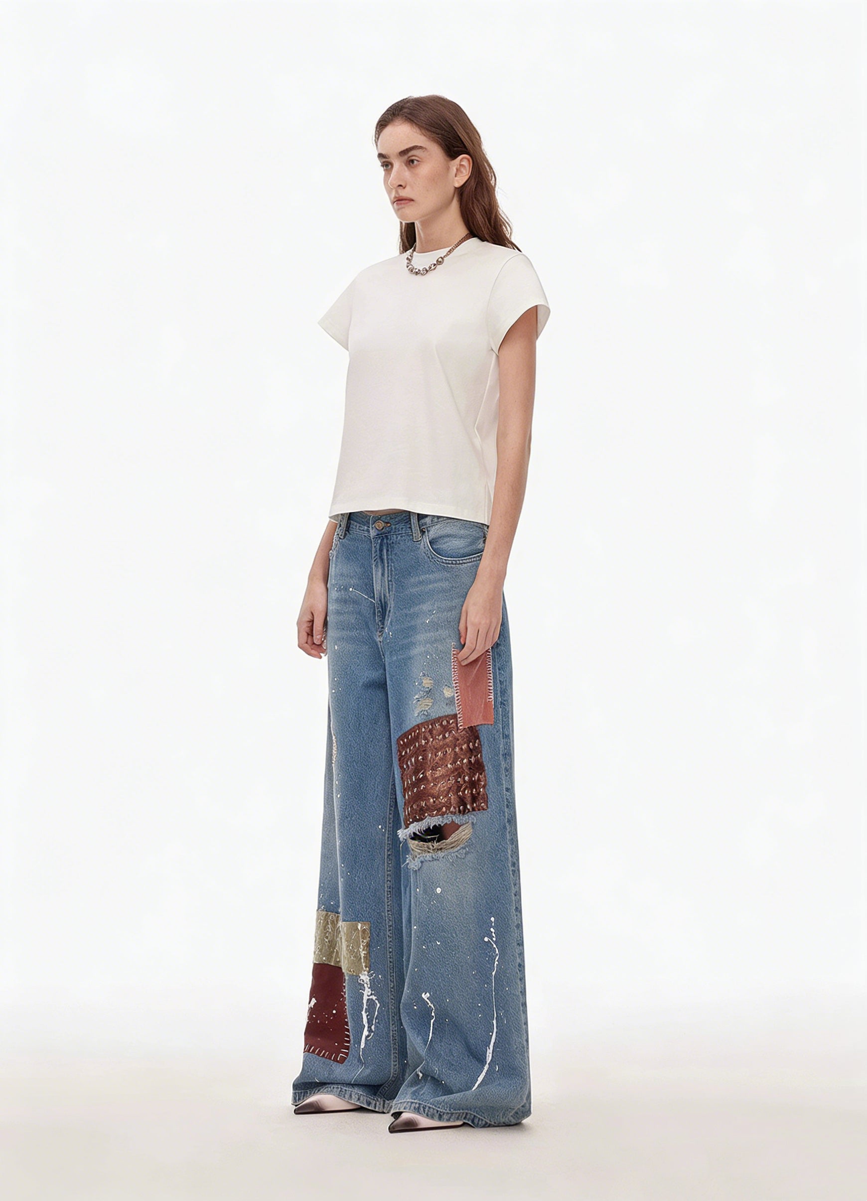 Side view of blue patchwork distressed wide-leg jeans