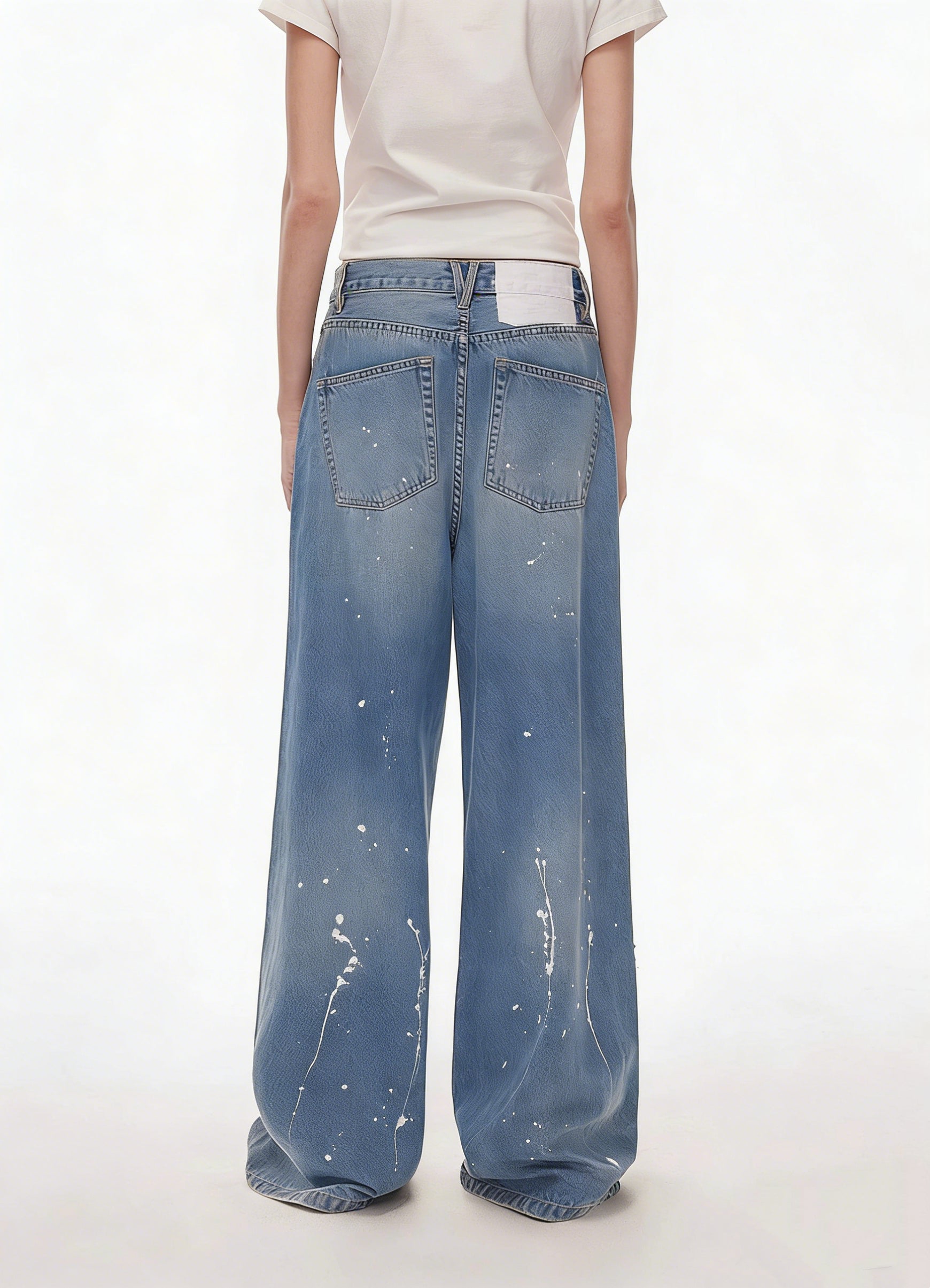 Back full-length view of blue patchwork distressed wide-leg jeans