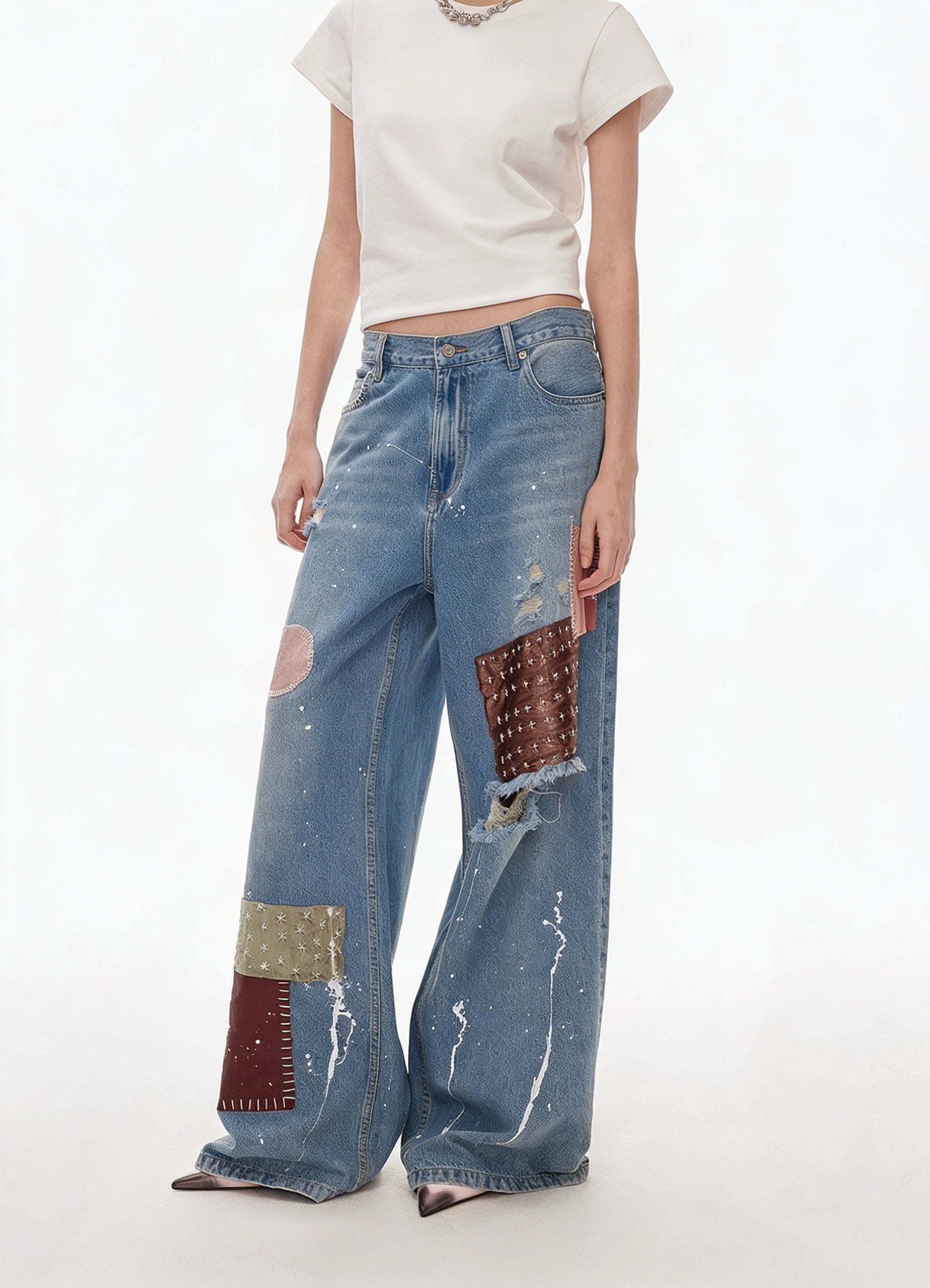 Three-quarter view of blue patchwork distressed wide-leg jeans