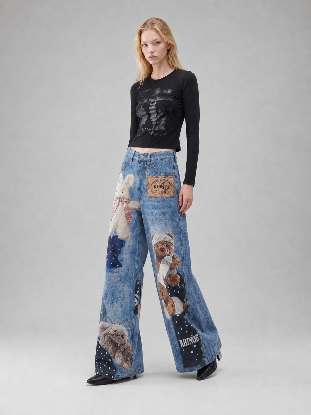 BapHood blue printed wide-leg jeans styled with a black top and oversized teddy bear graphics.