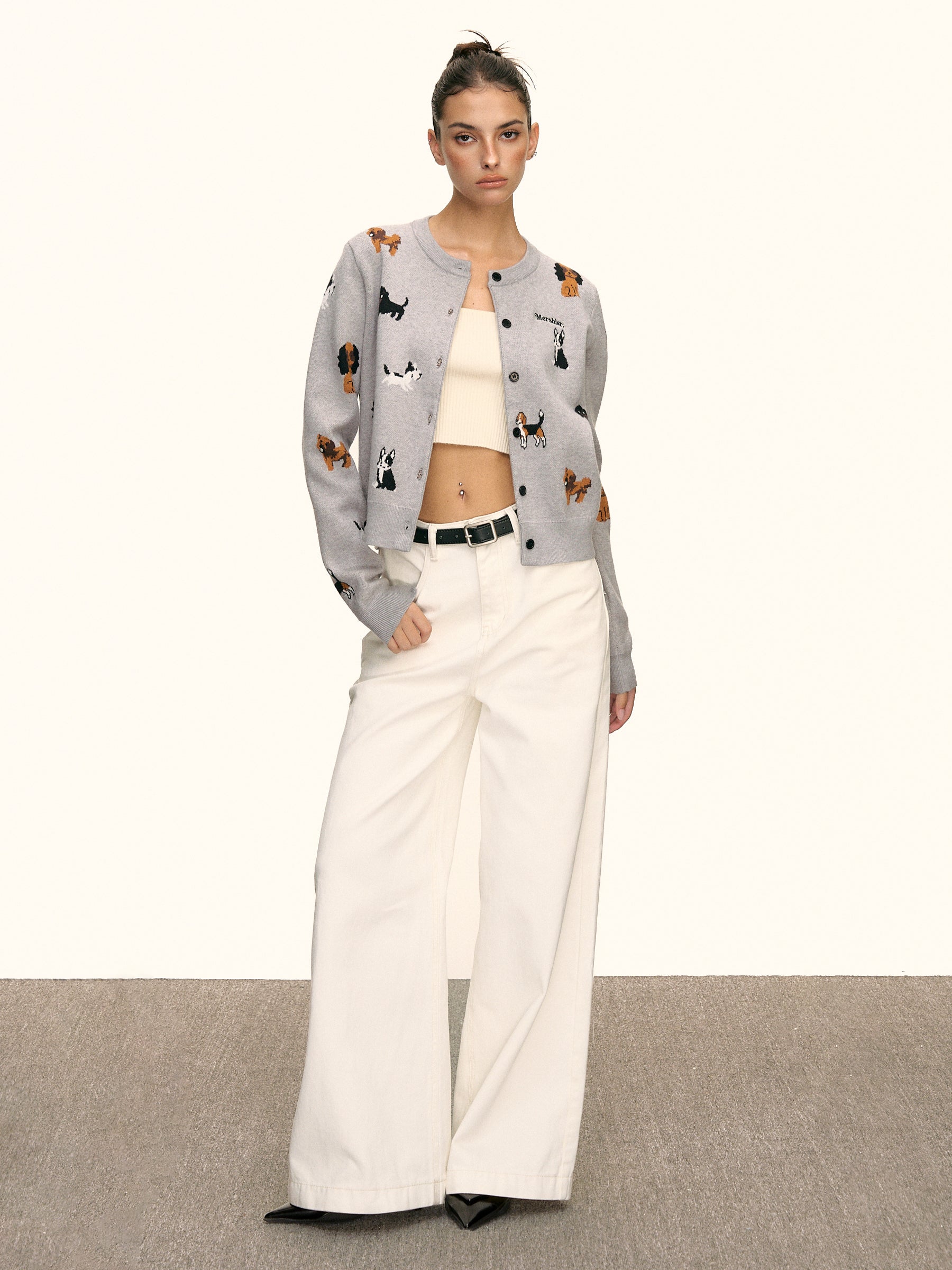 Model wearing grey puppy knit cardigan with cream wide-leg pants