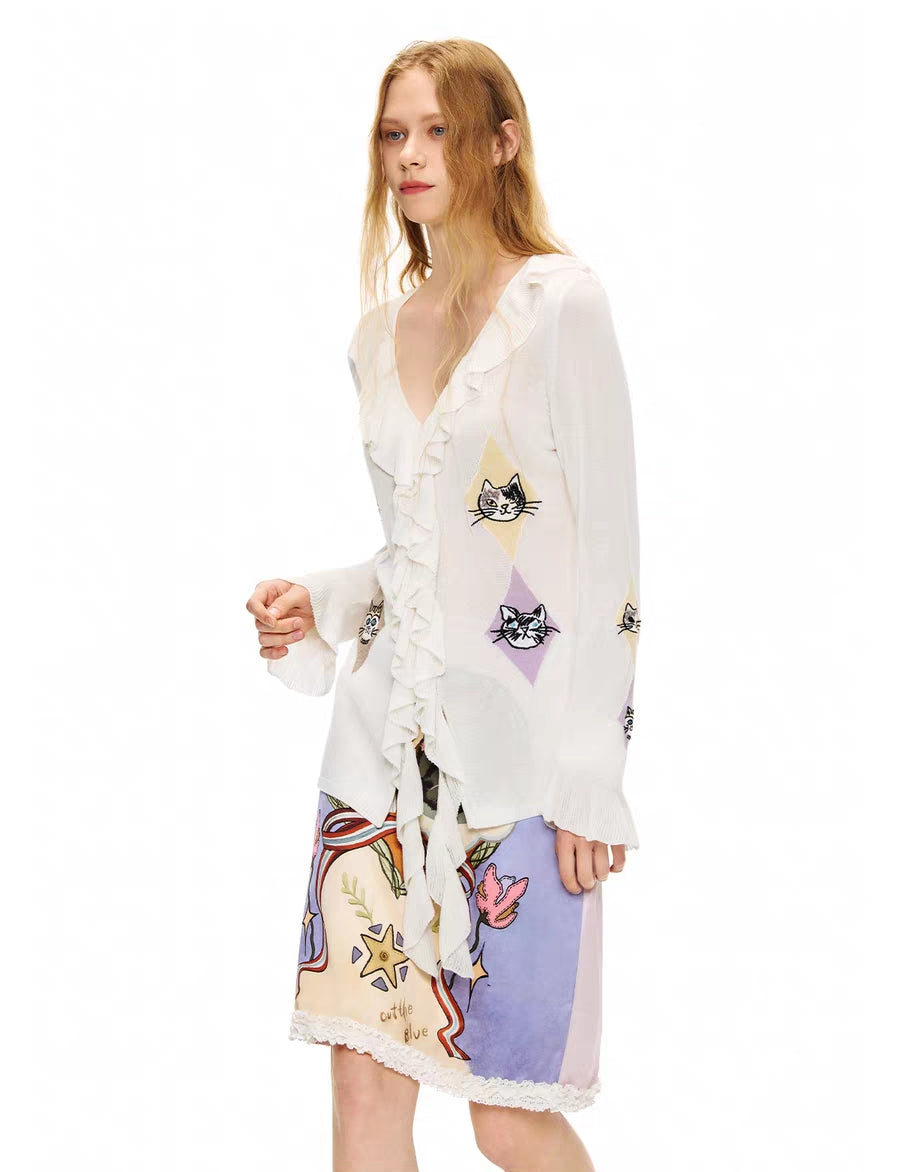 Angled front view of ruffle V-neck tie-front kitty argyle cardigan top