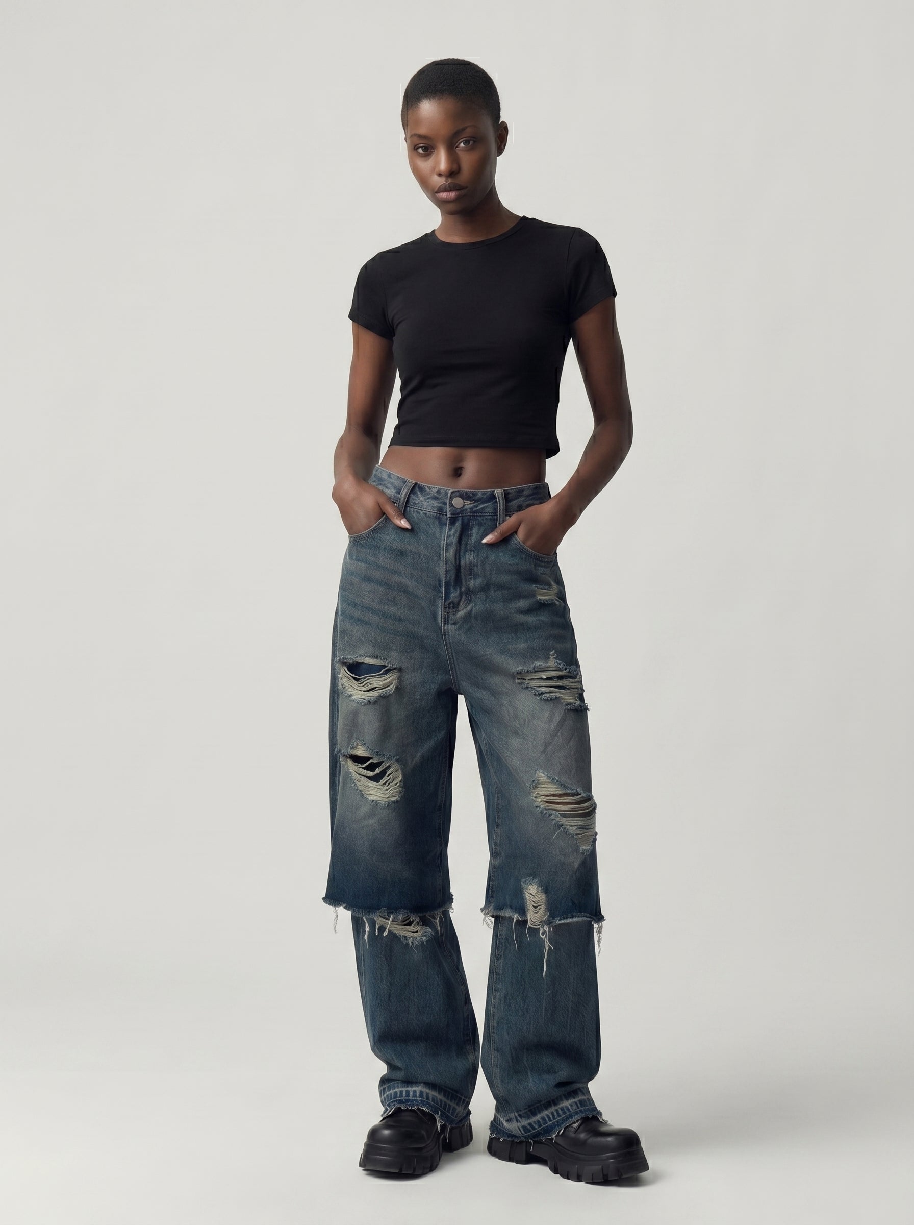 Model wearing double-layer ripped jeans in washed charcoal