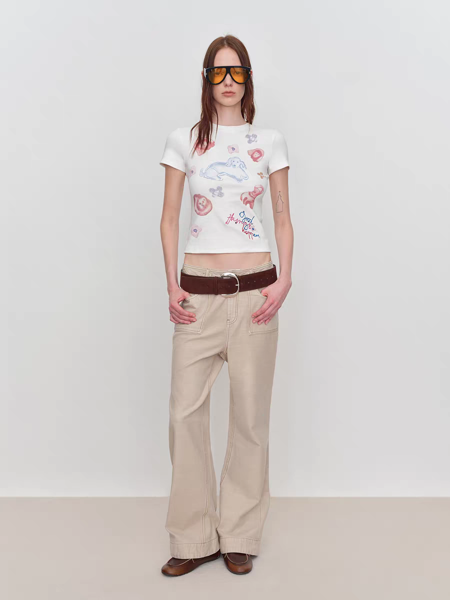 Model wearing white fitted baby tee with puppy graphic and slogan print, front view