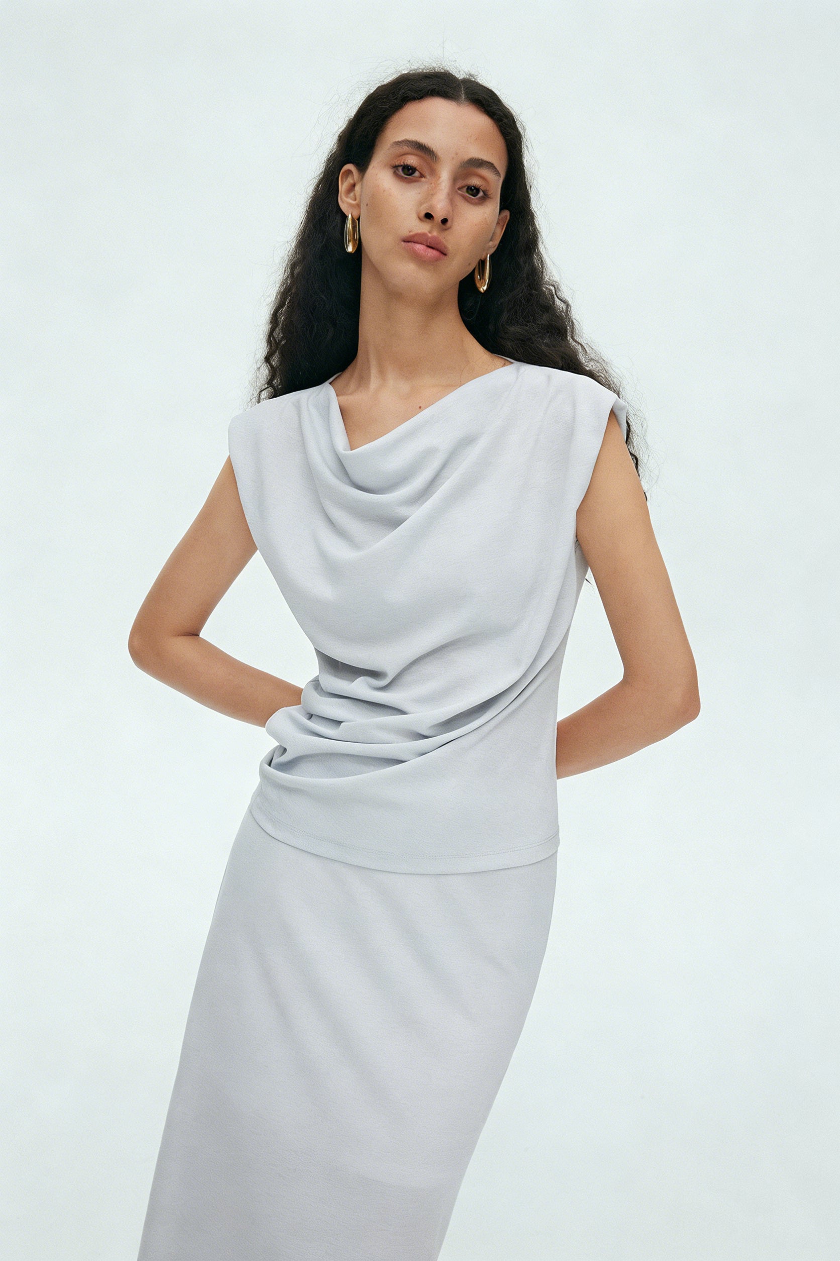 BapHood light gray sleeveless draped cowl top side view styled with minimalist maxi skirt