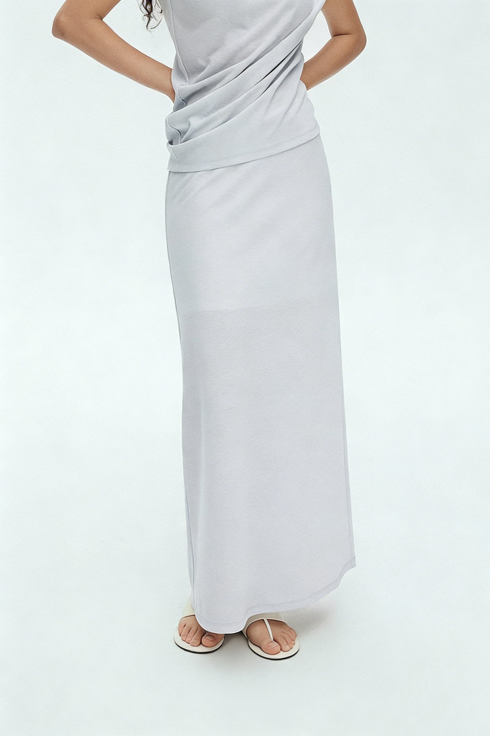 BapHood light gray sleeveless draped top paired with smooth flowing maxi skirt in minimalist set