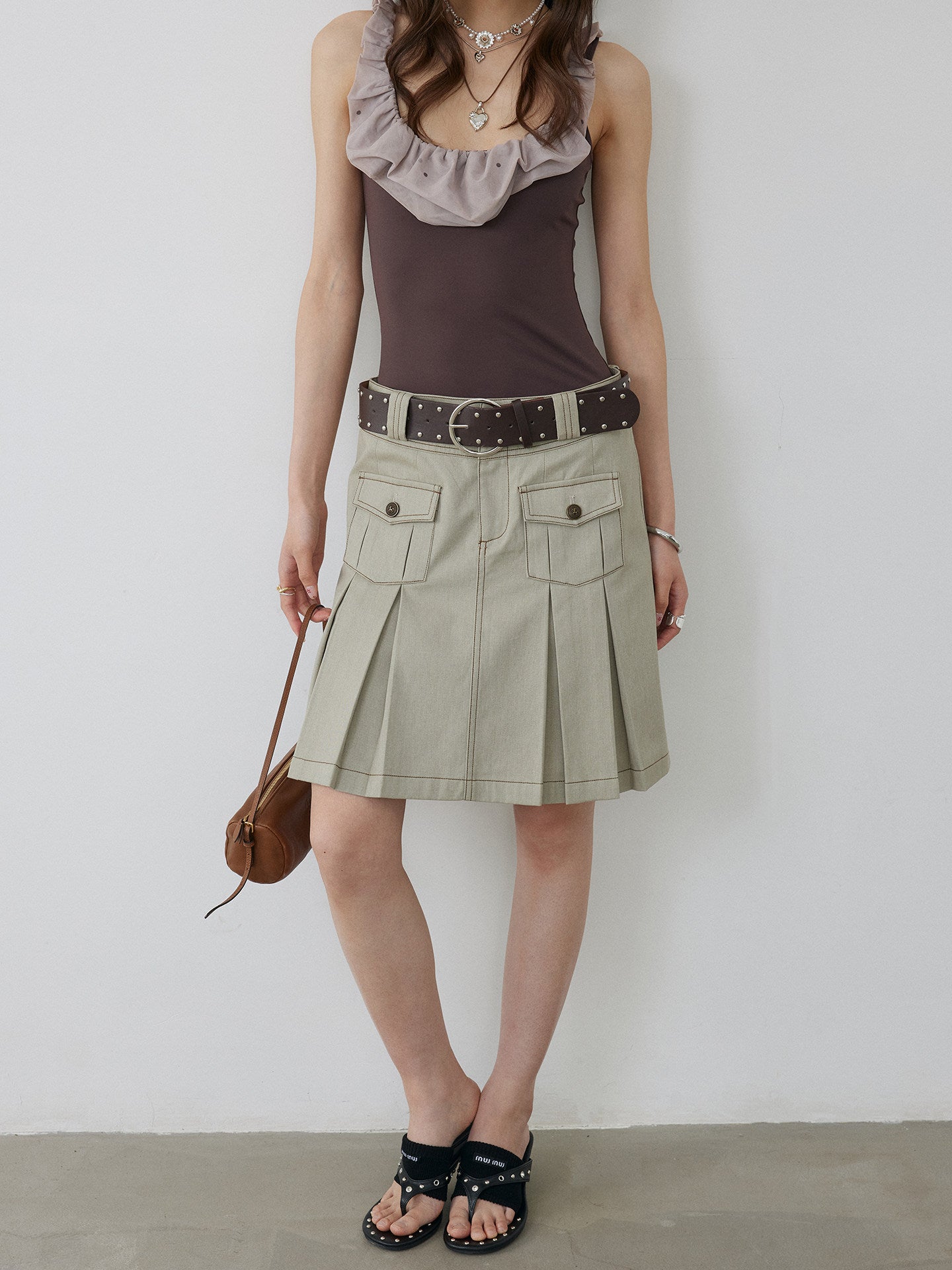 BapHood khaki grey pleated skirt with close front pocket detail, belt styling, and visible stitching.