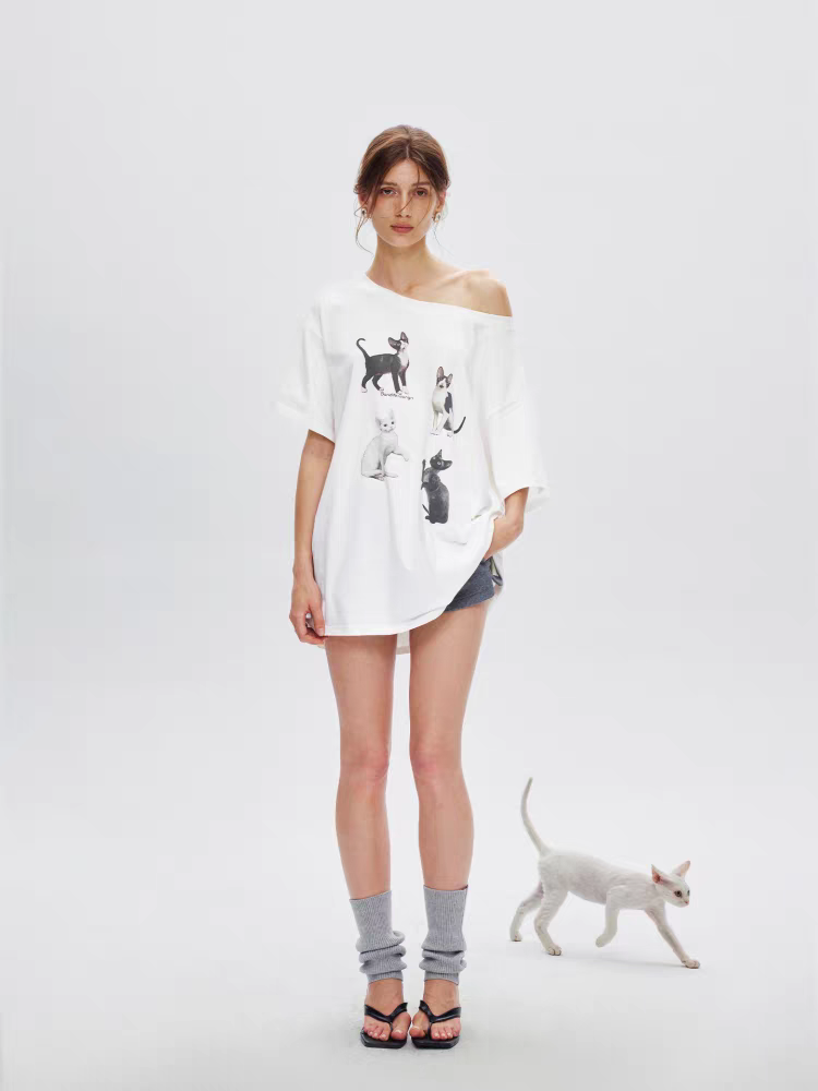 Full body front view of white tee dress styled as oversized top with cat graphic