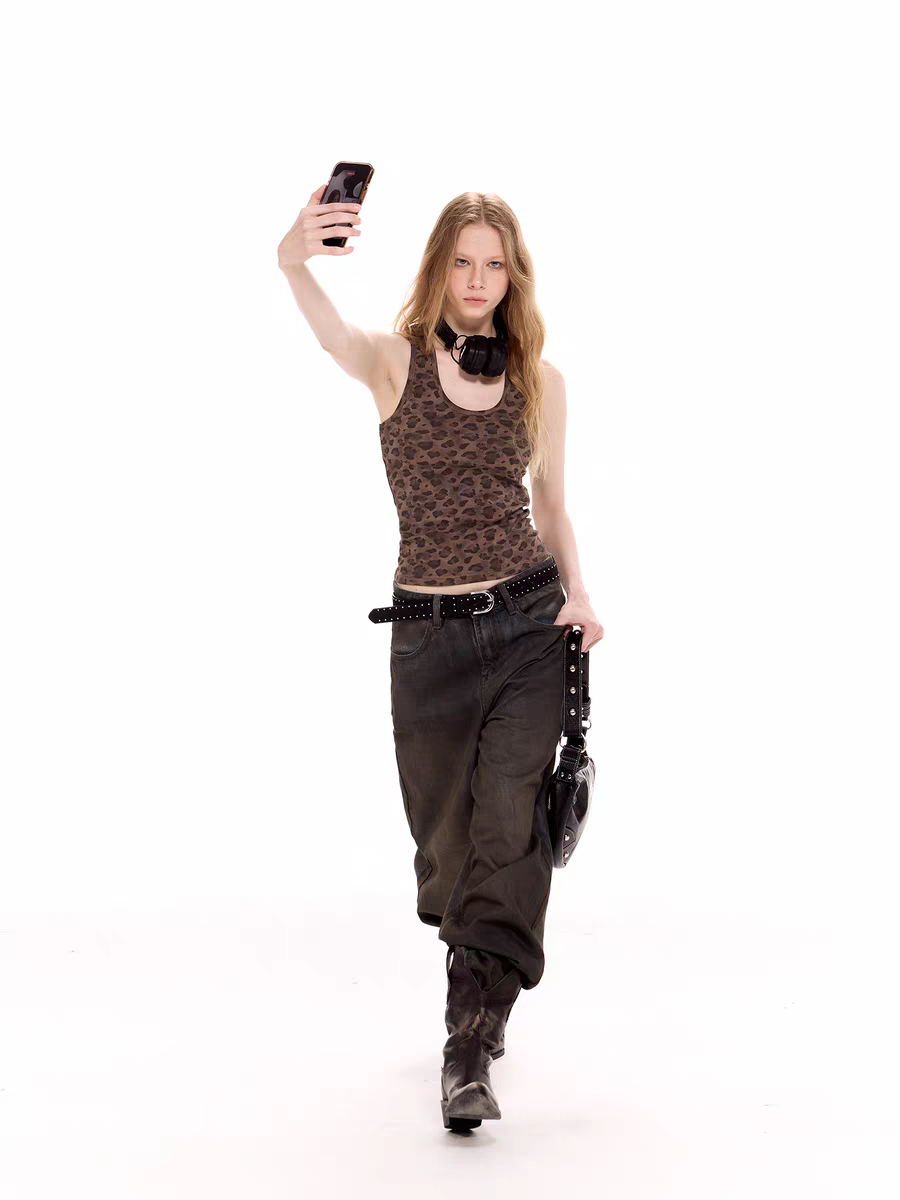 Full-body front view of model wearing leopard tank top styled with dark jeans