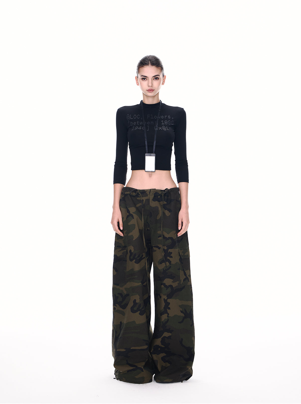 Ultra wide camo parachute cargo pants in army green on model, front view