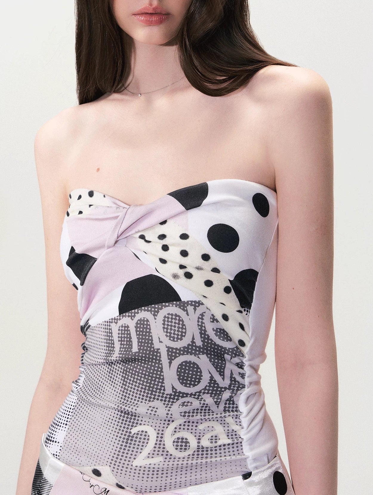 Close-up of twist-front bust detail on polka collage strapless top