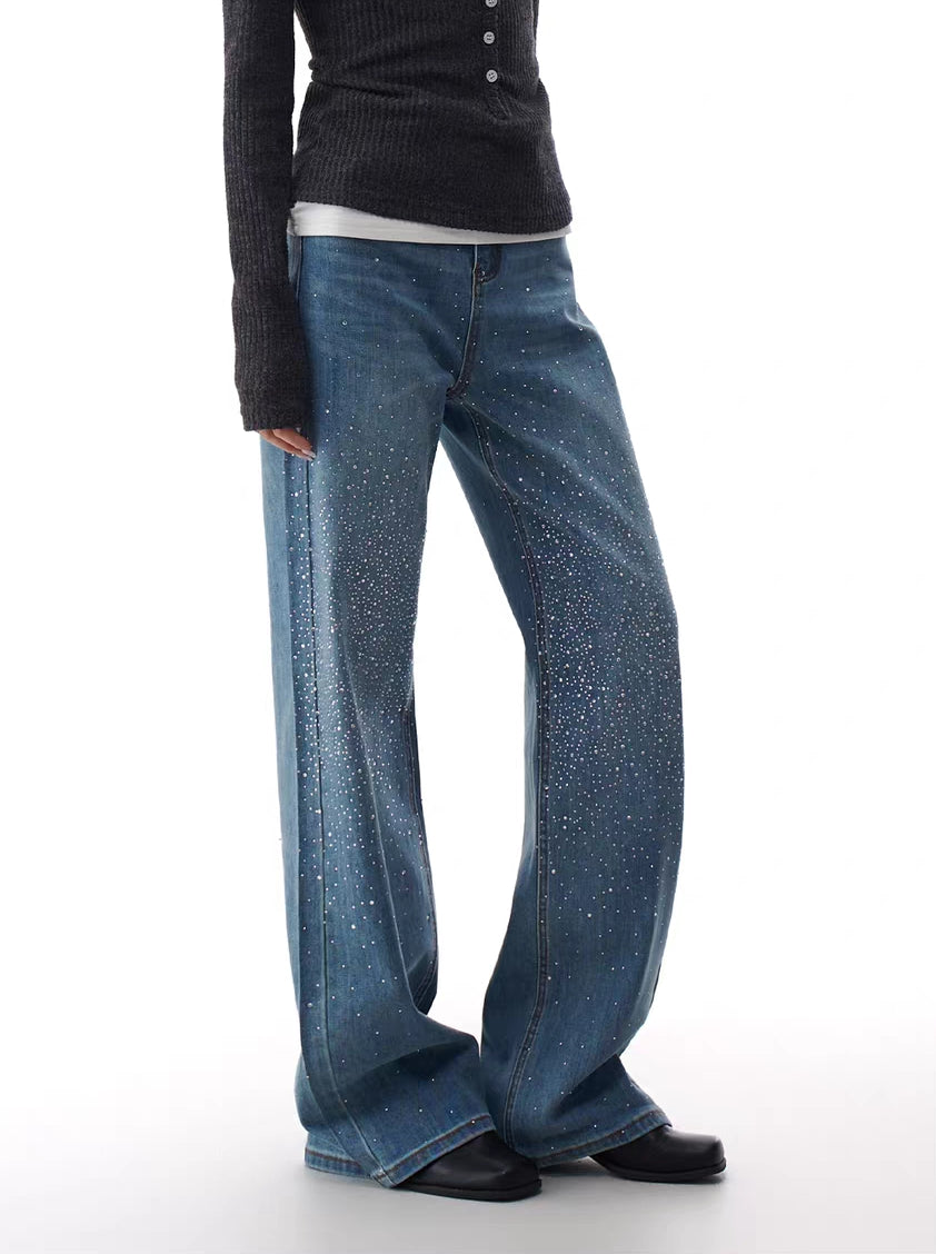 Model wearing blue flare jeans with rhinestone stardust gradient detailing.