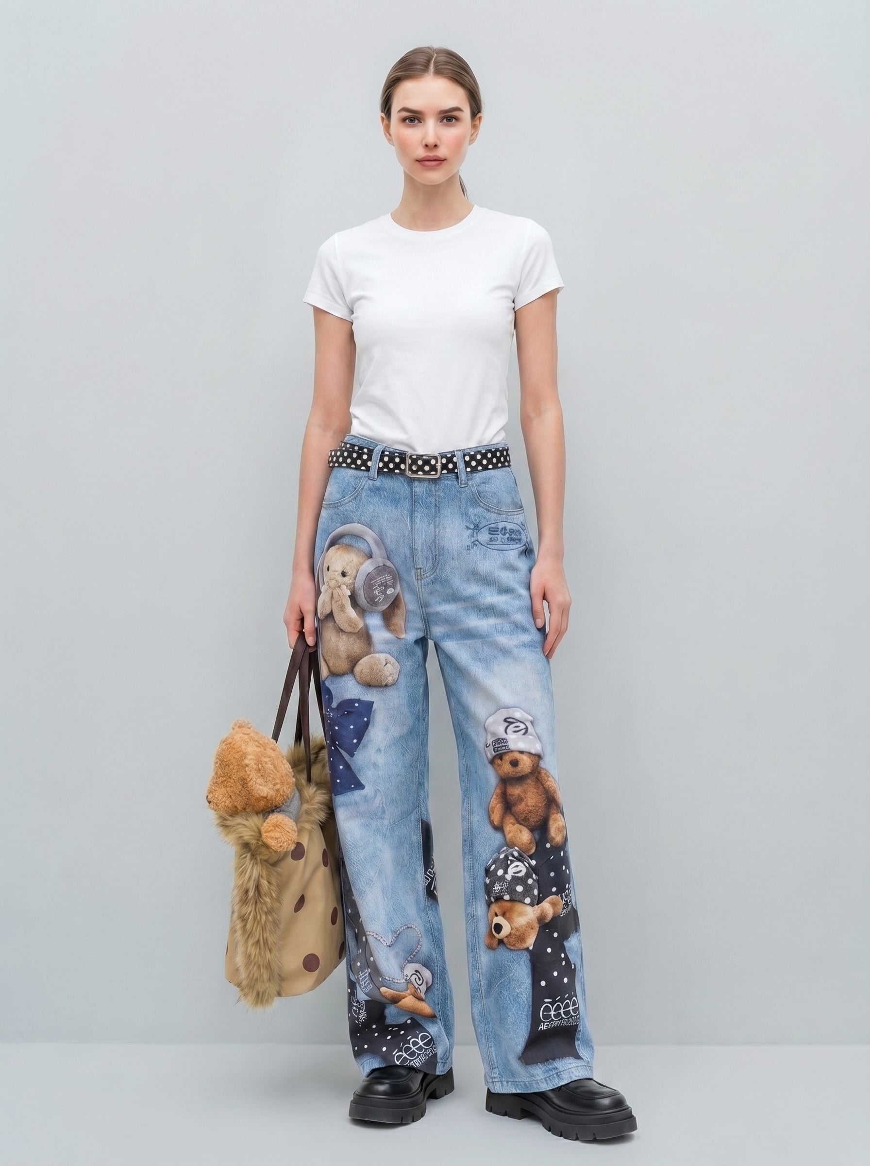 Front view of light wash wide-leg jeans with teddy bear and bow graphic print, model wearing