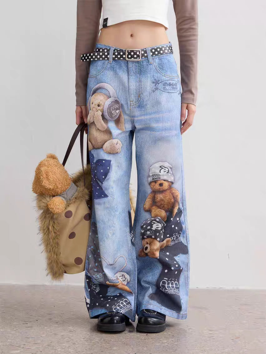 Front view of light wash wide-leg jeans with teddy bear and bow graphic print, model wearing