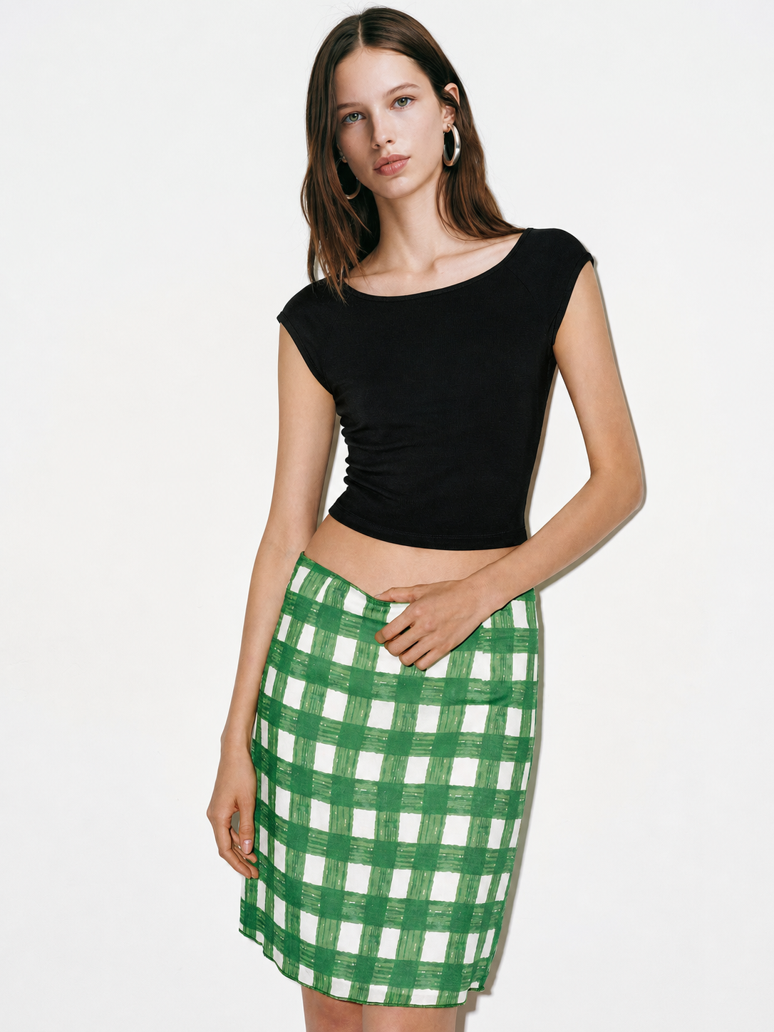 Black cap sleeve crop top styled with green check skirt