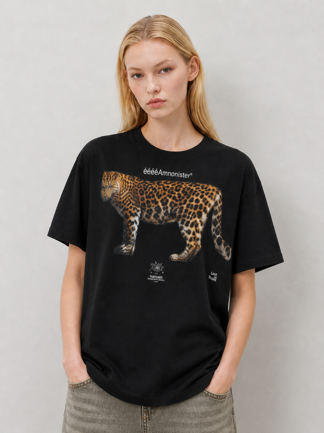 Front detail of black oversized T-shirt featuring a large leopard graphic print and small white logo text