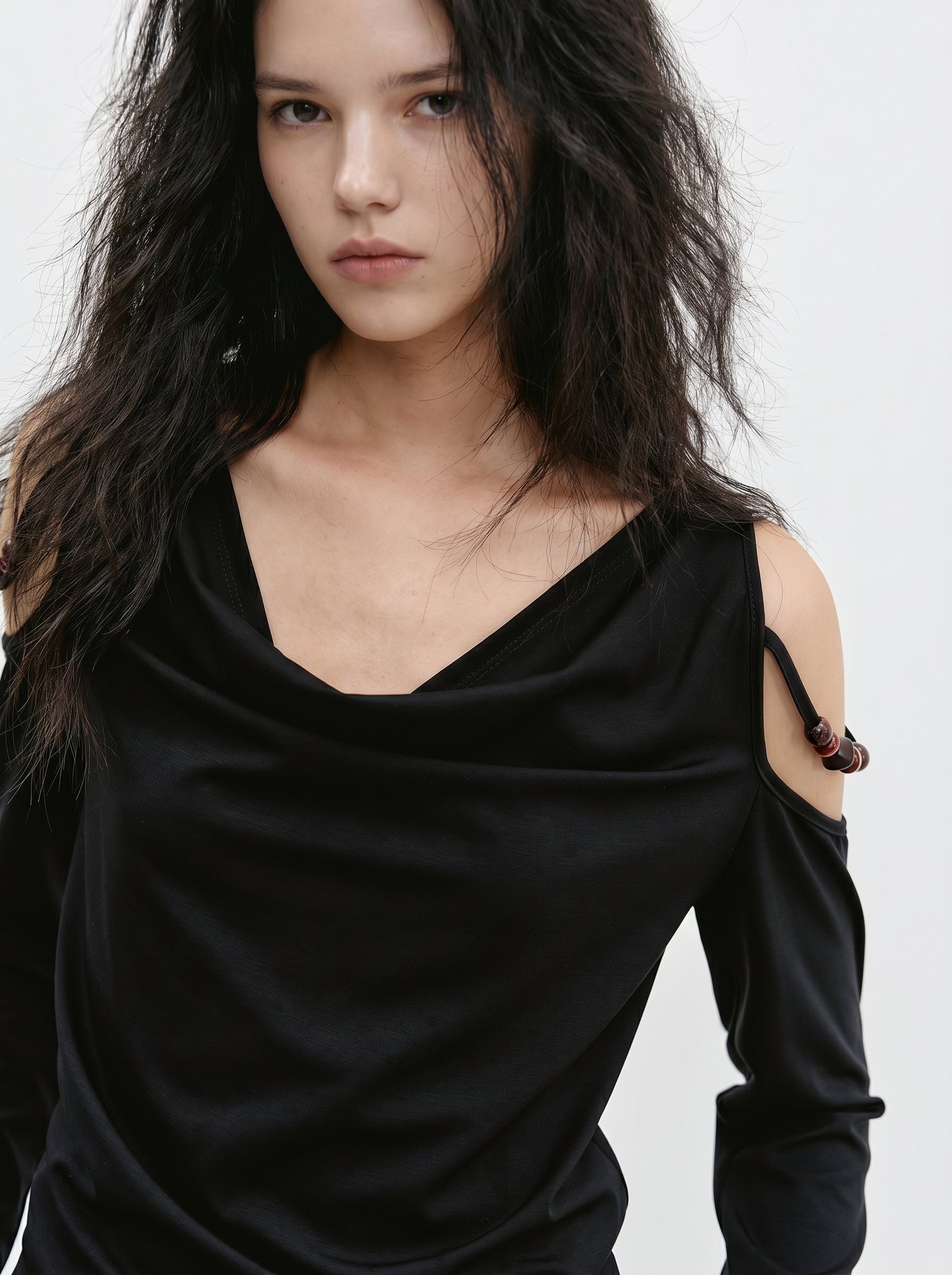 Close-up of black off shoulder long sleeve top with draped neckline