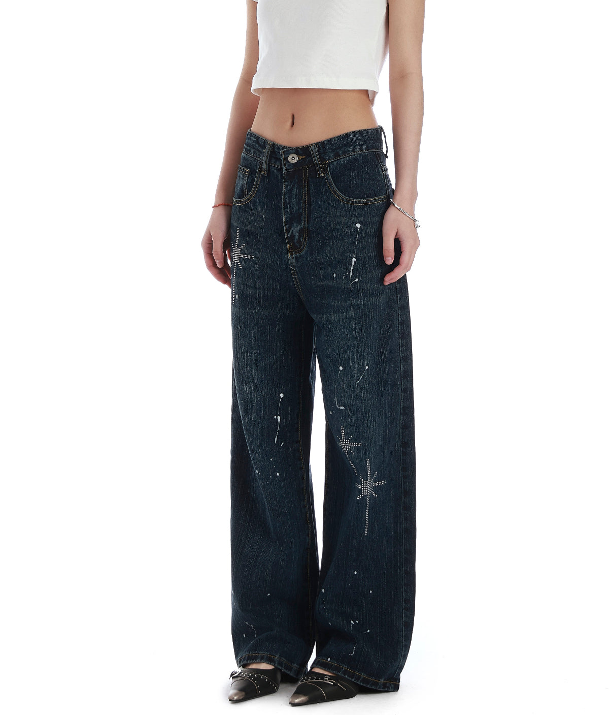Model wearing black rhinestone wide leg jeans in a relaxed front pose with one hand in pocket