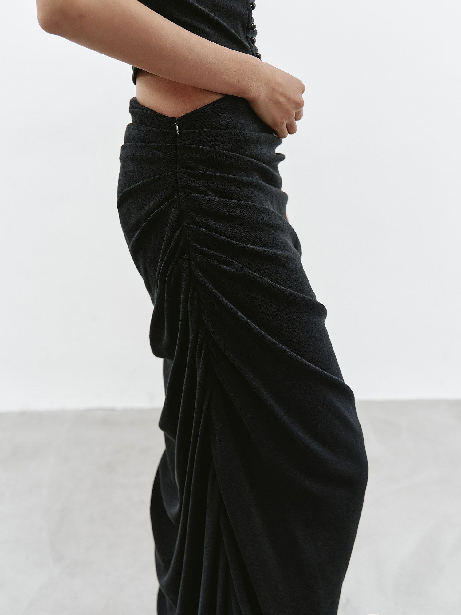 Close-up of black ruched maxi skirt waist and gathered side detail