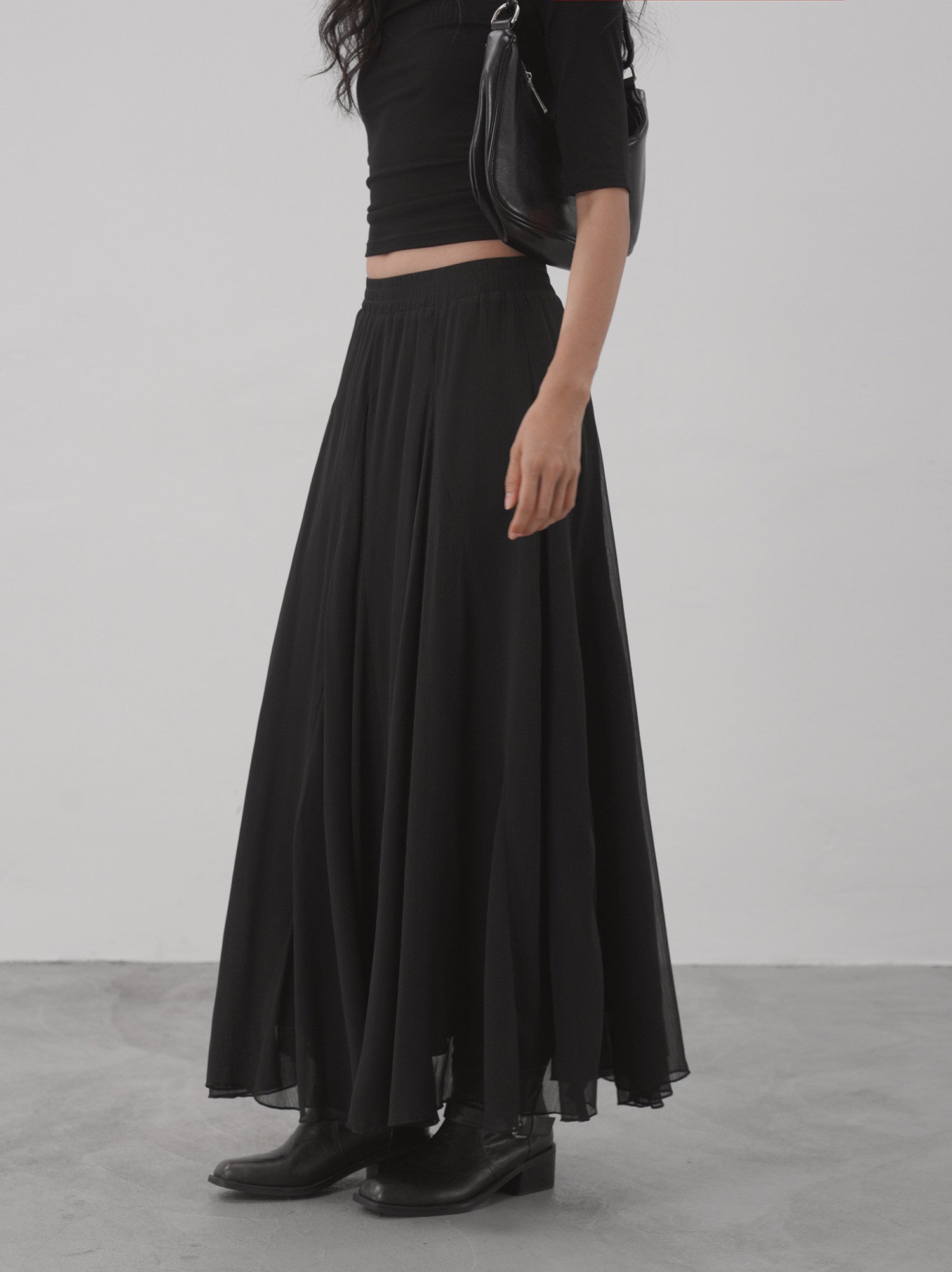 Black sheer flared maxi skirt side view showing A-line drape