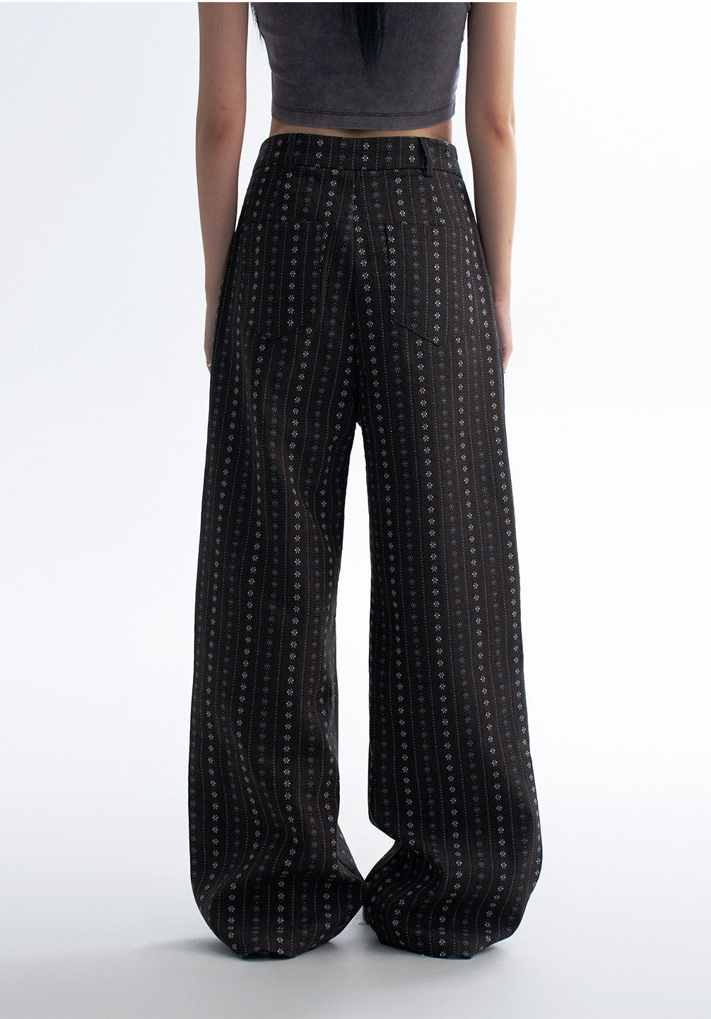 Detail view of black striped wide leg pants showing the full length, soft drape, and vertical patterned fabric