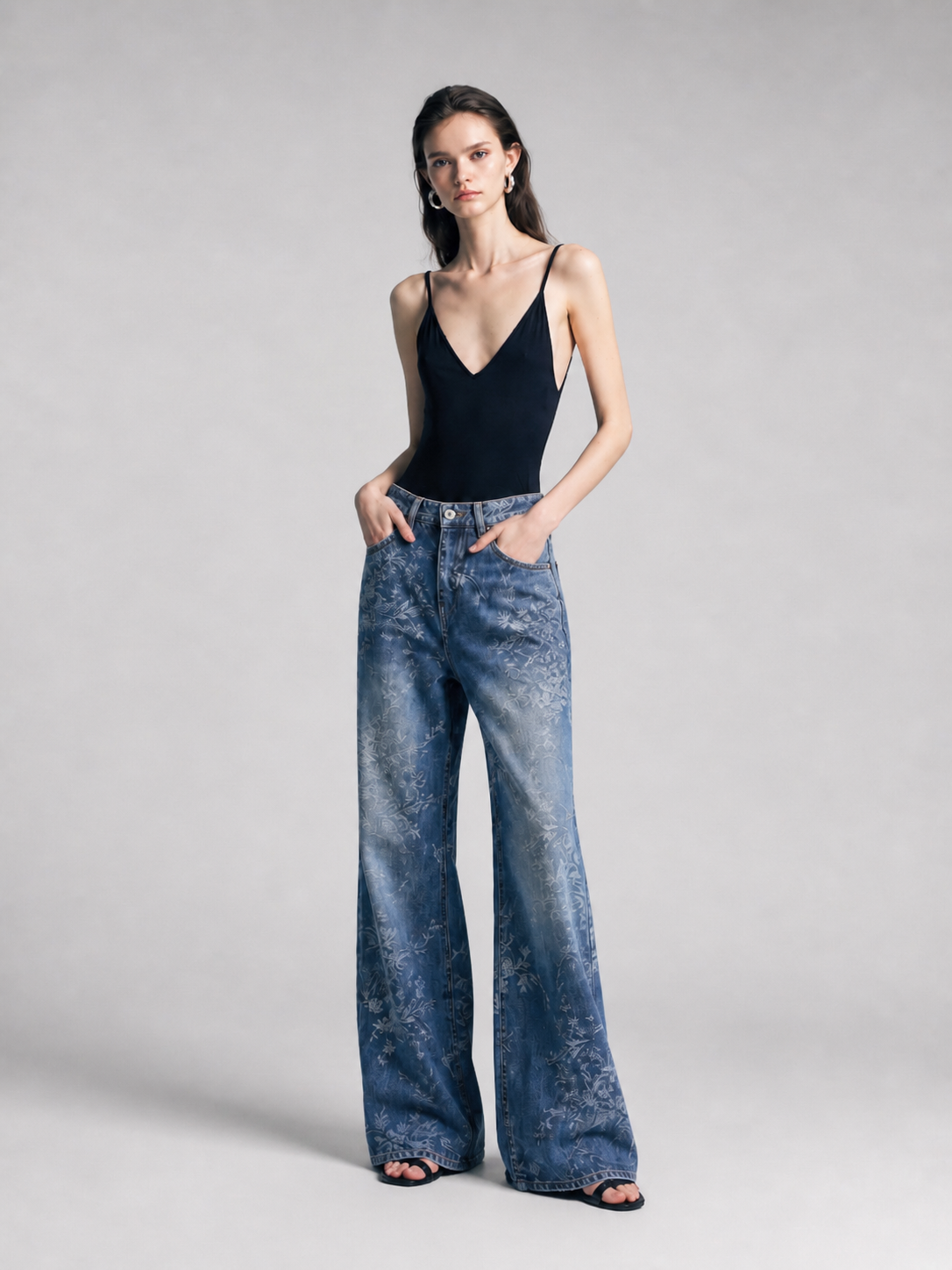 Model in blue jacquard wide-leg jeans, angled front pose with hands in pockets.