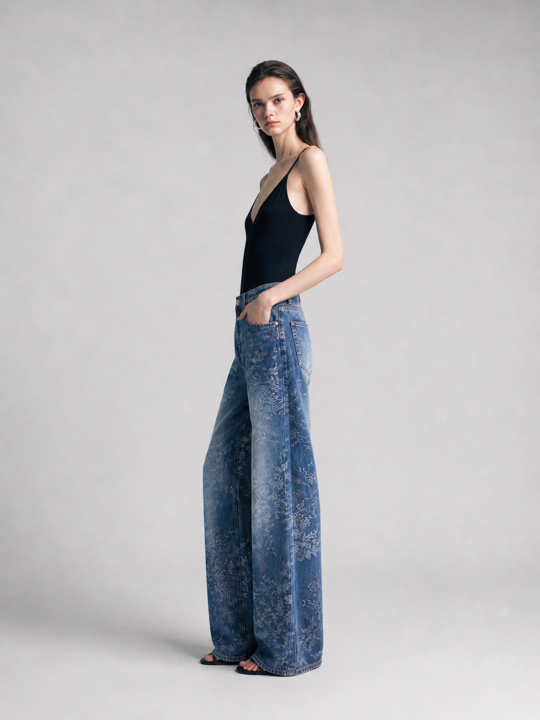 Full-length front view of blue jacquard wide-leg jeans on model.