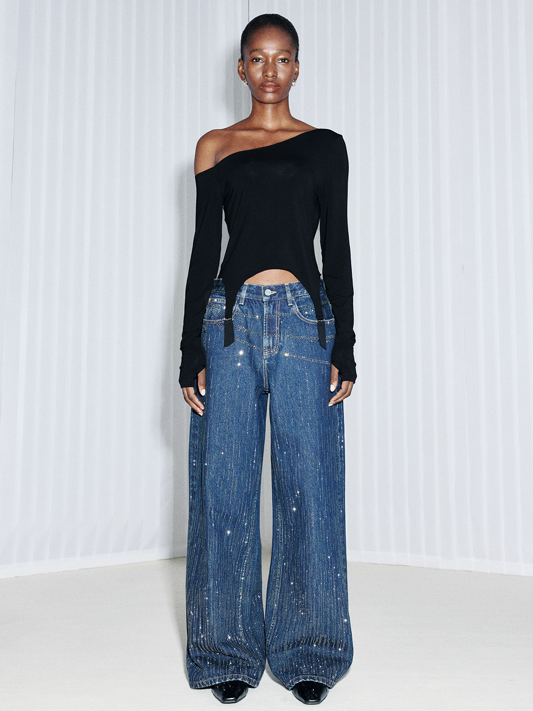 Front view of blue wide-leg jeans showing the loose fit, long length, and statement denim design
