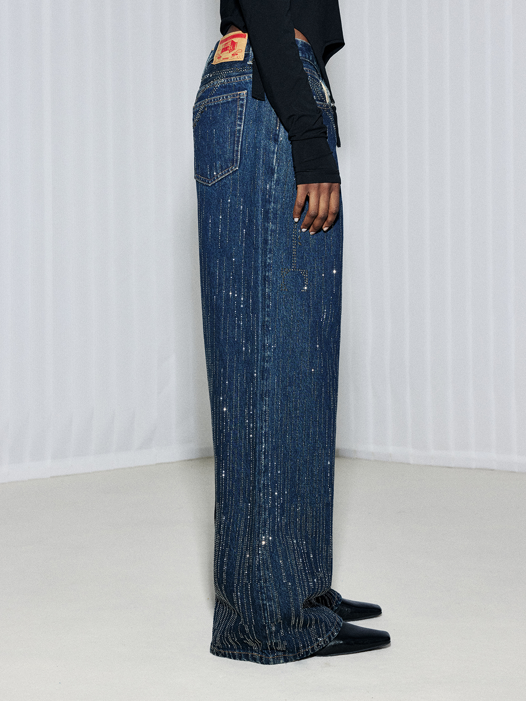 Side view of blue wide-leg jeans showing the flowing leg shape and full-length silhouette