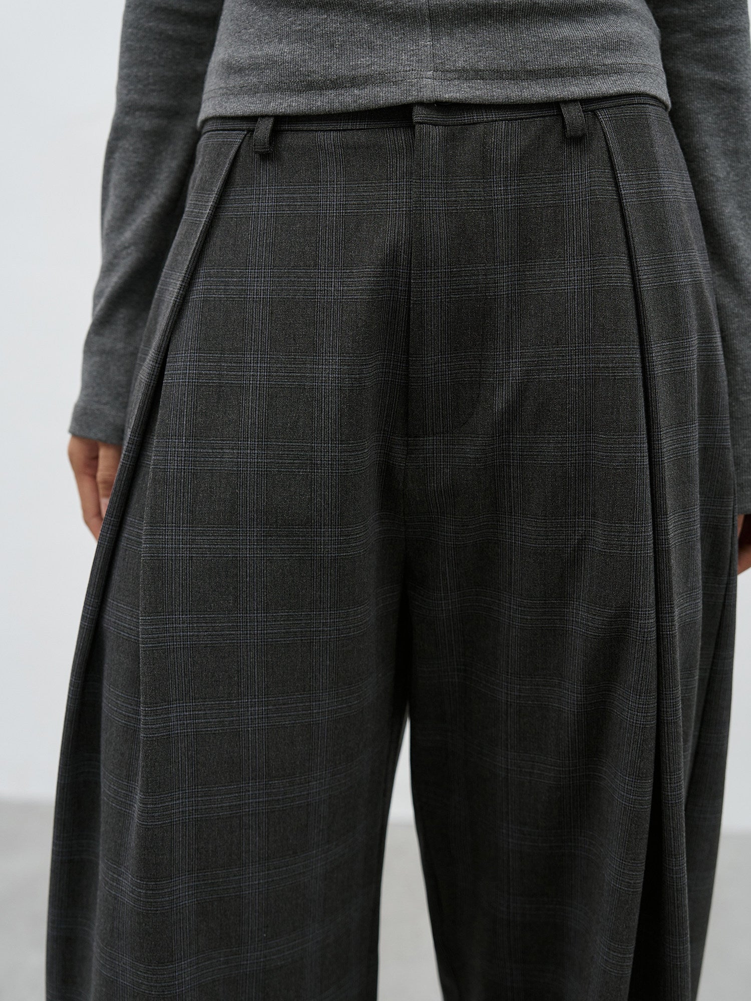 Waist and pleat detail of charcoal plaid wide leg pants