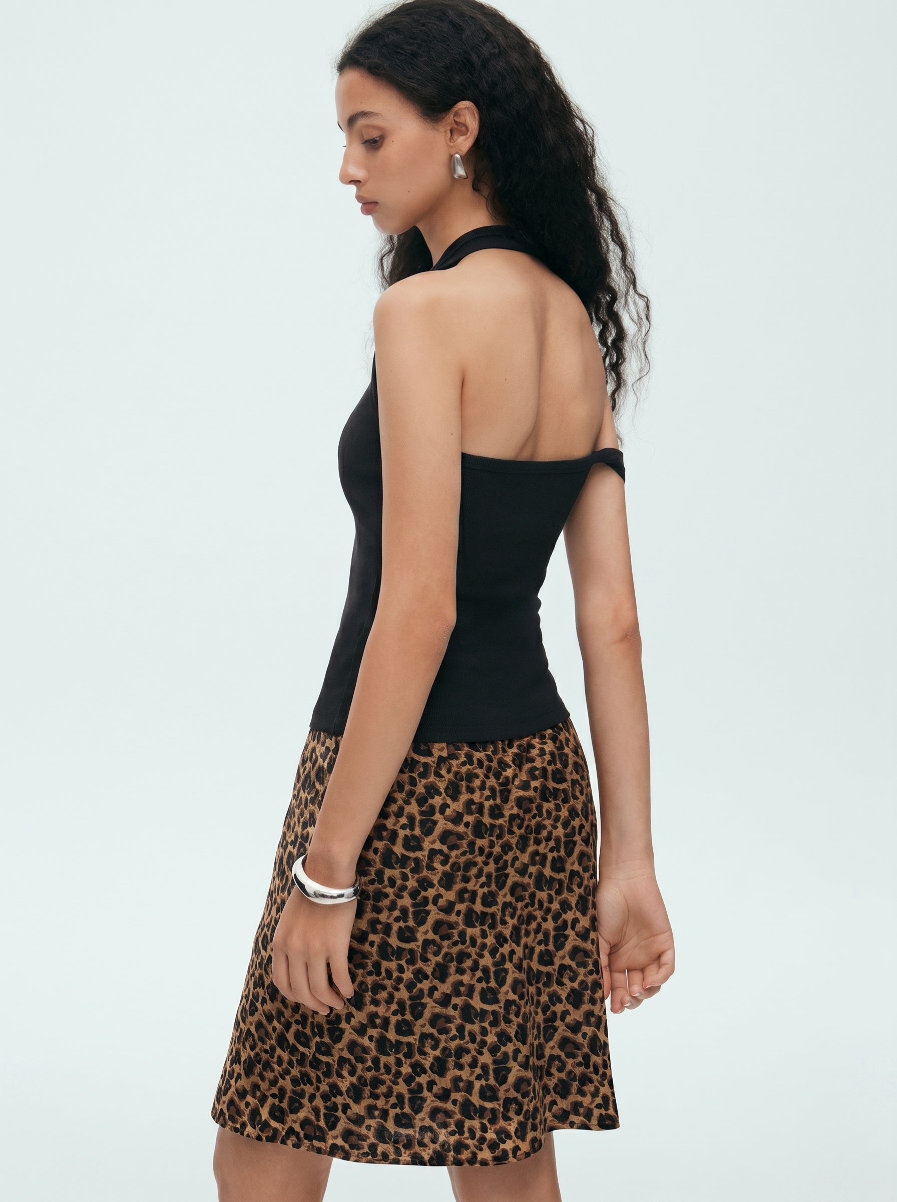 Back view of black convertible halter off shoulder top showing the asymmetric shoulder strap design