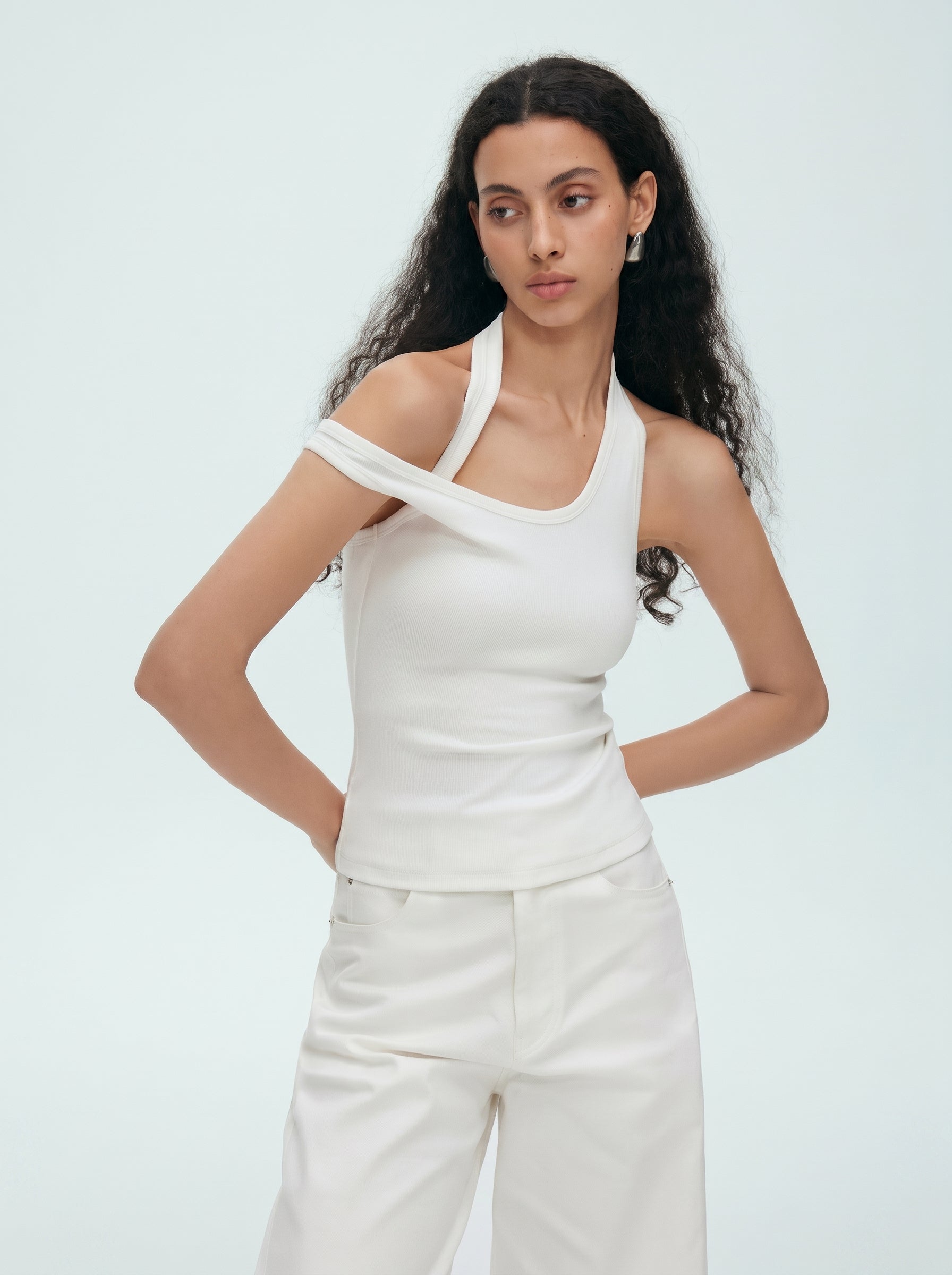 Front view of white convertible halter off shoulder top styled with white pants