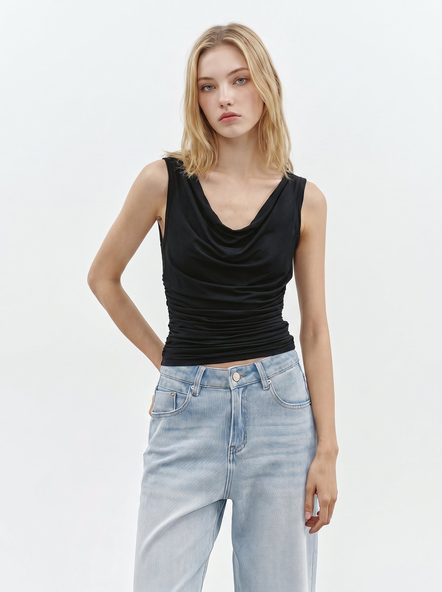 Black cowl neck sleeveless top styled with light wash jeans
