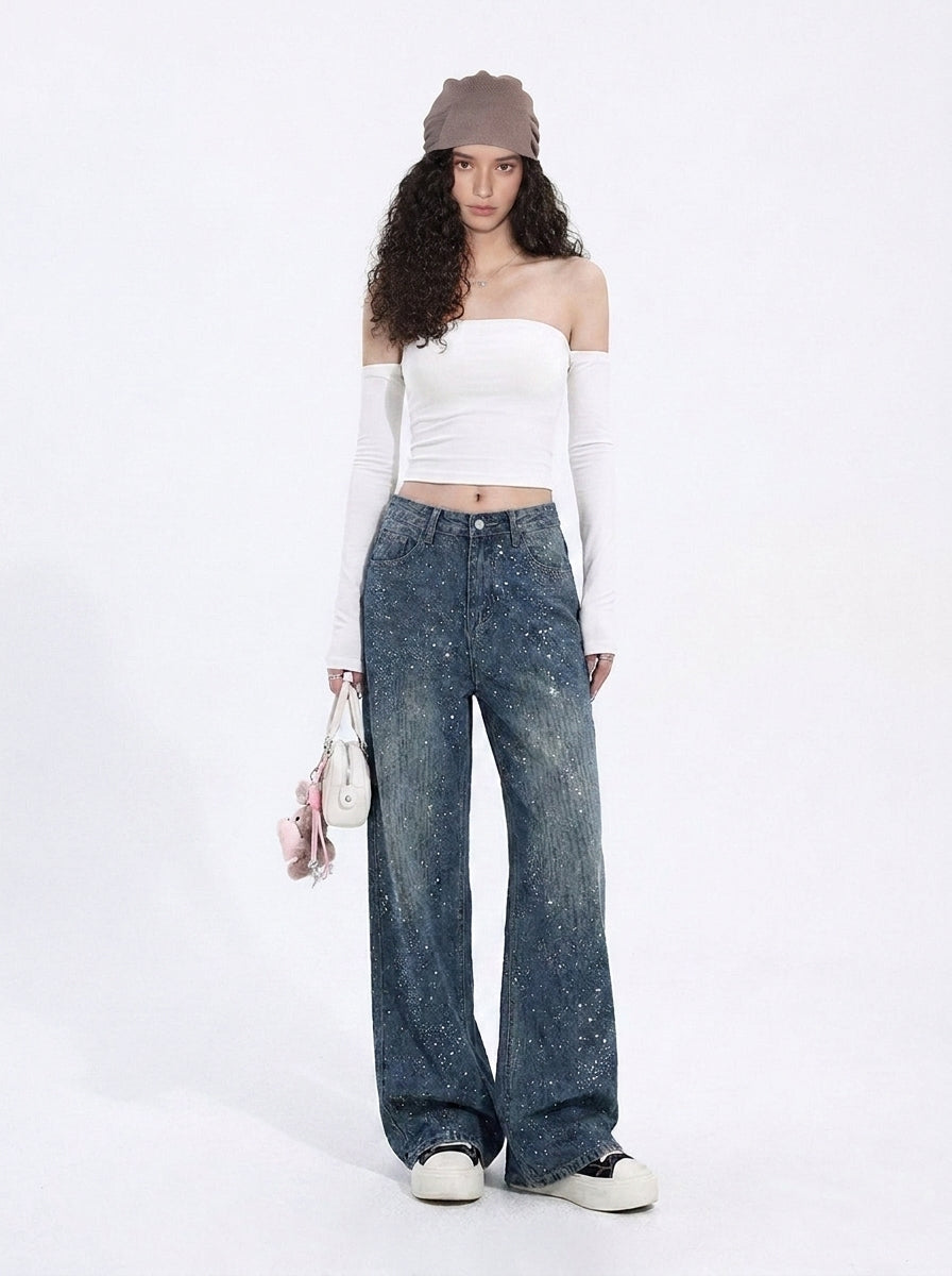 Front view of dark wash rhinestone wide leg jeans styled with a white top