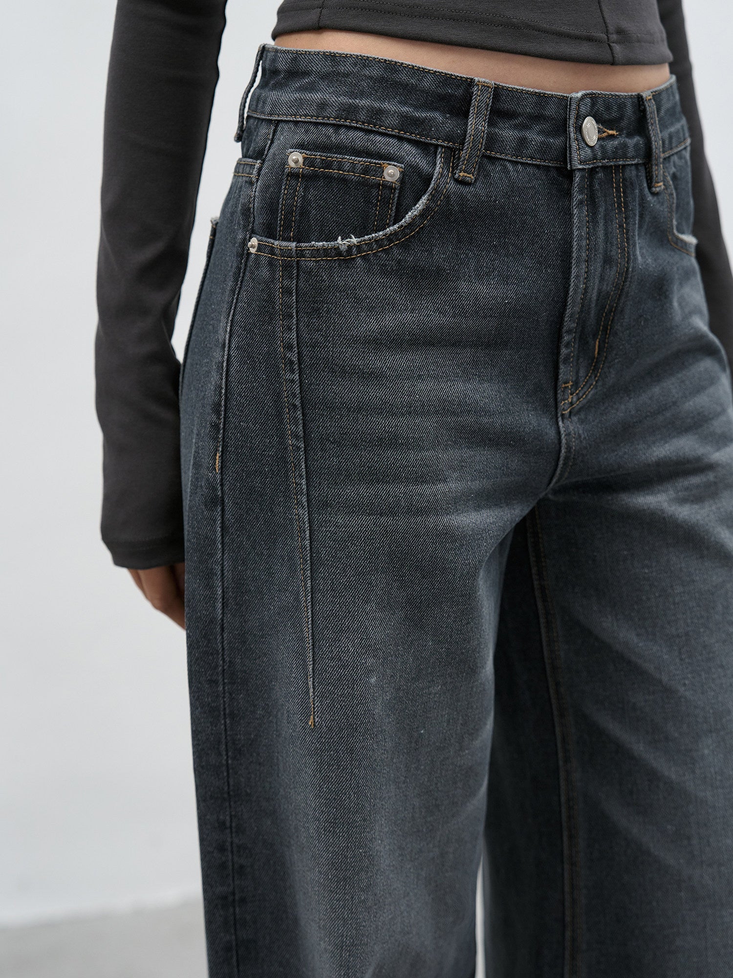 Waistband and front pocket detail of dark wash wide leg jeans
