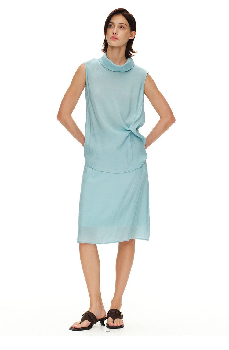 Model wearing light blue turtleneck top and midi skirt set with hands on waist