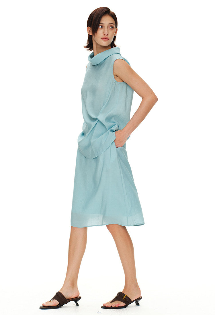Side view of light blue sleeveless turtleneck top and matching midi skirt set showing the soft drape