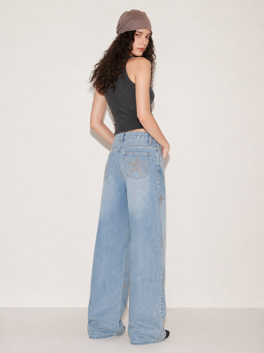 Back view of light wash wide leg jeans with silver star embellishments