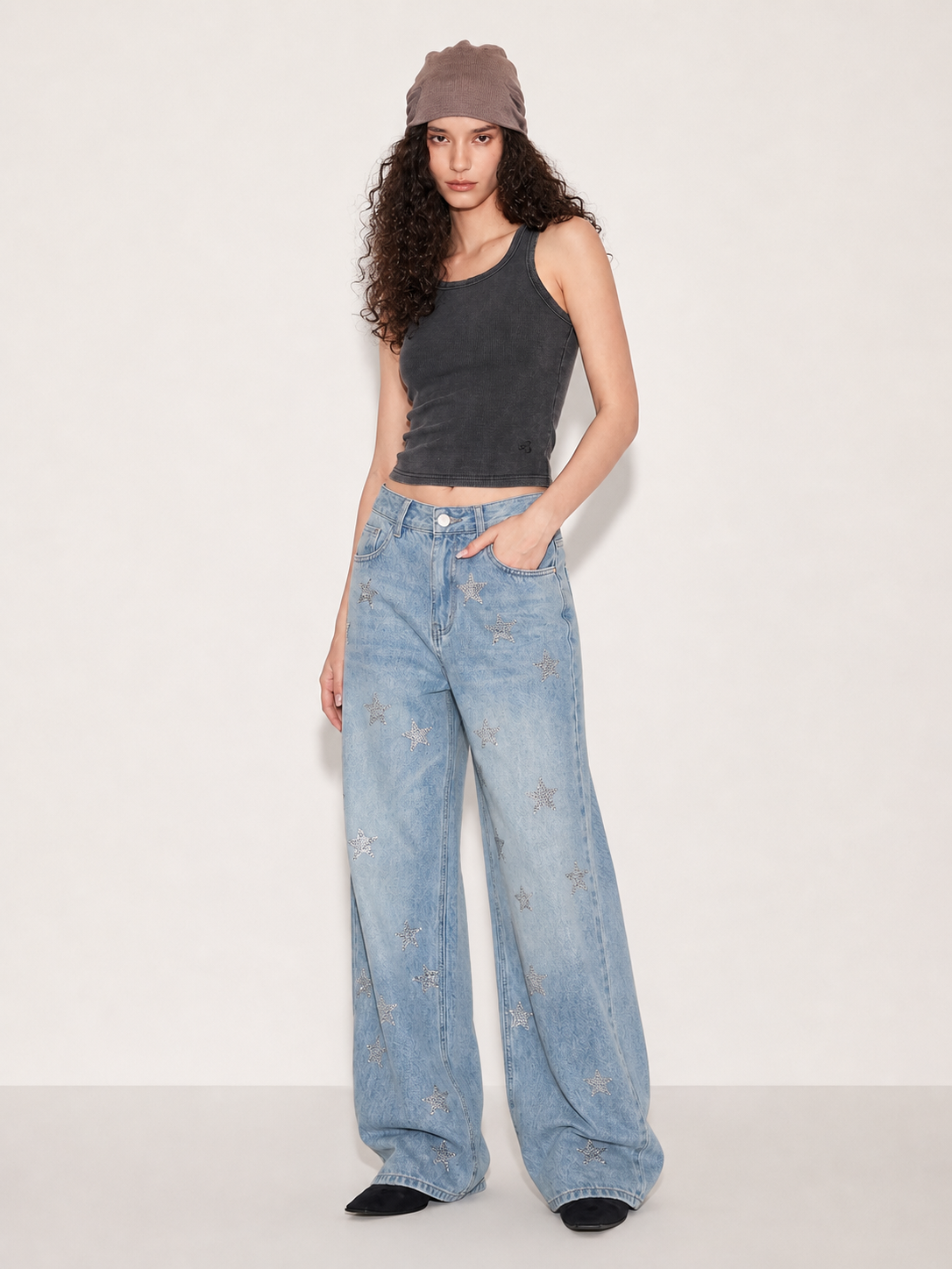 Light wash wide leg jeans with silver star embellishments shown in a front angled pose
