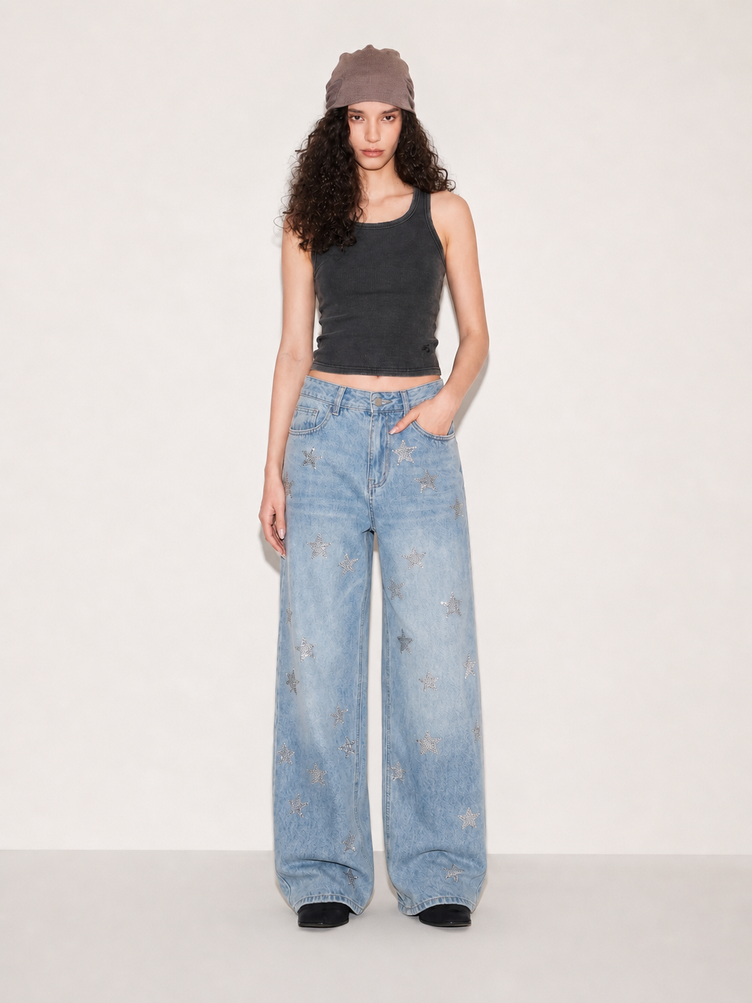 Model in light wash wide leg jeans with silver star embellishments in a relaxed front pose