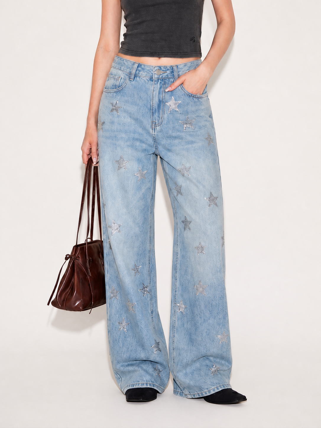 Full length front view of light wash wide leg jeans with silver star embellishments