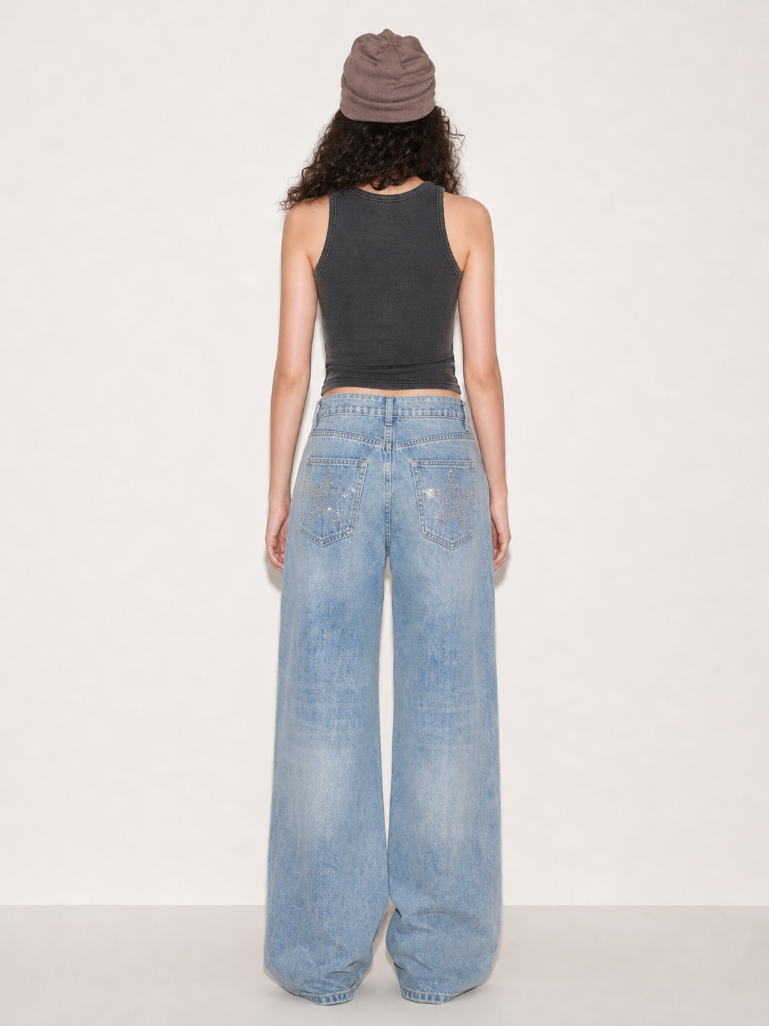 Close-up of the leg shape and silver star embellishments on light wash wide leg jeans