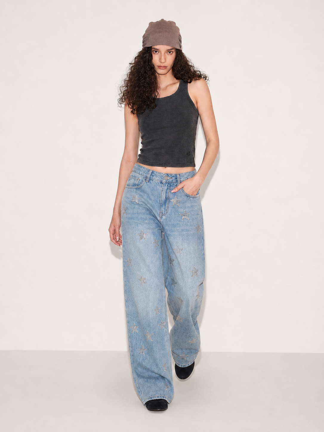 Close-up of light wash wide leg jeans with silver star embellishments and front waist detail
